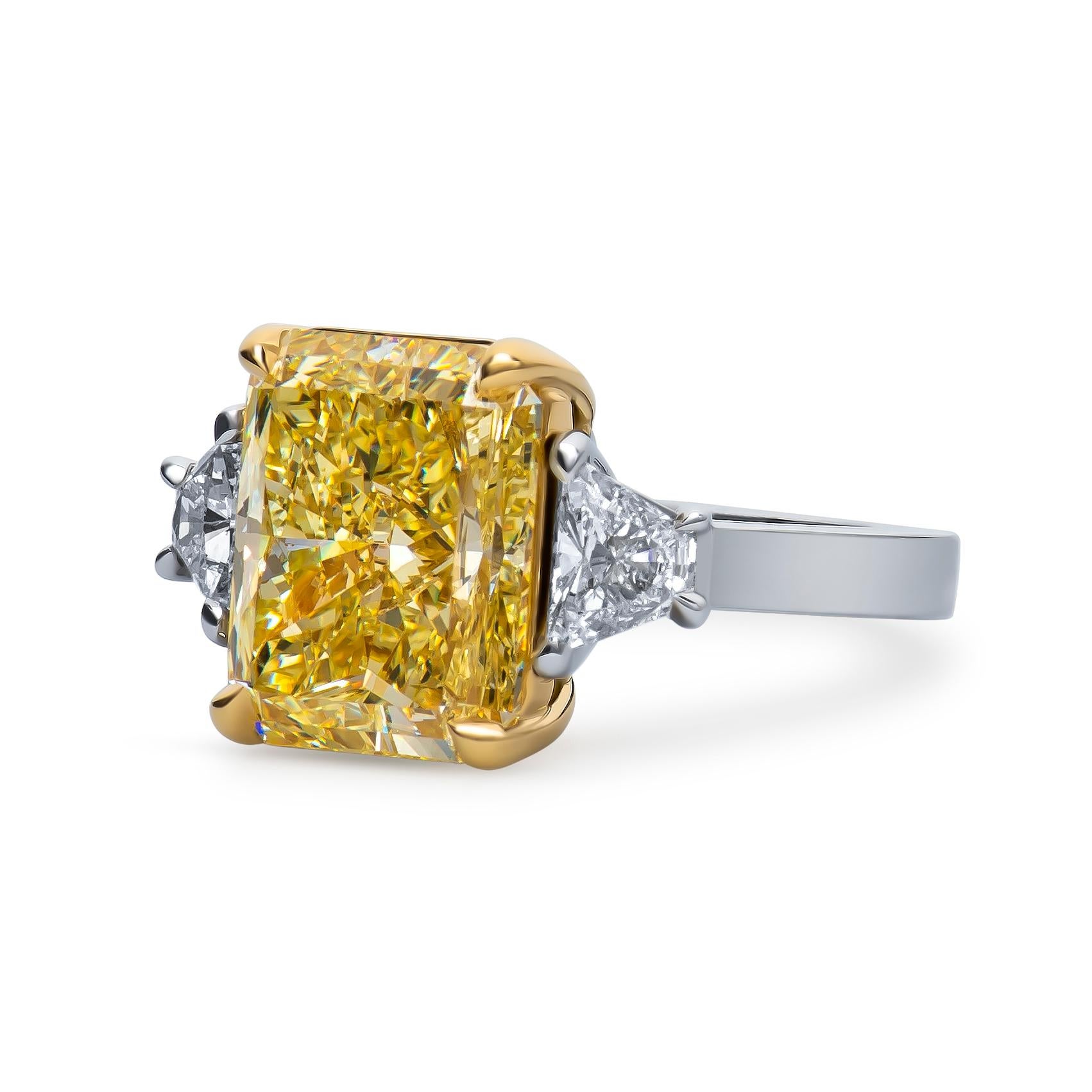 7.32 Carat natural fancy color radiant cut diamond, SI1 clarity (GIA report), set in a platinum ring with an 18k yellow gold center setting and 0.70 carats total weight in side trapezoid brilliant cut diamonds. Size 6.25, may be resized to larger or