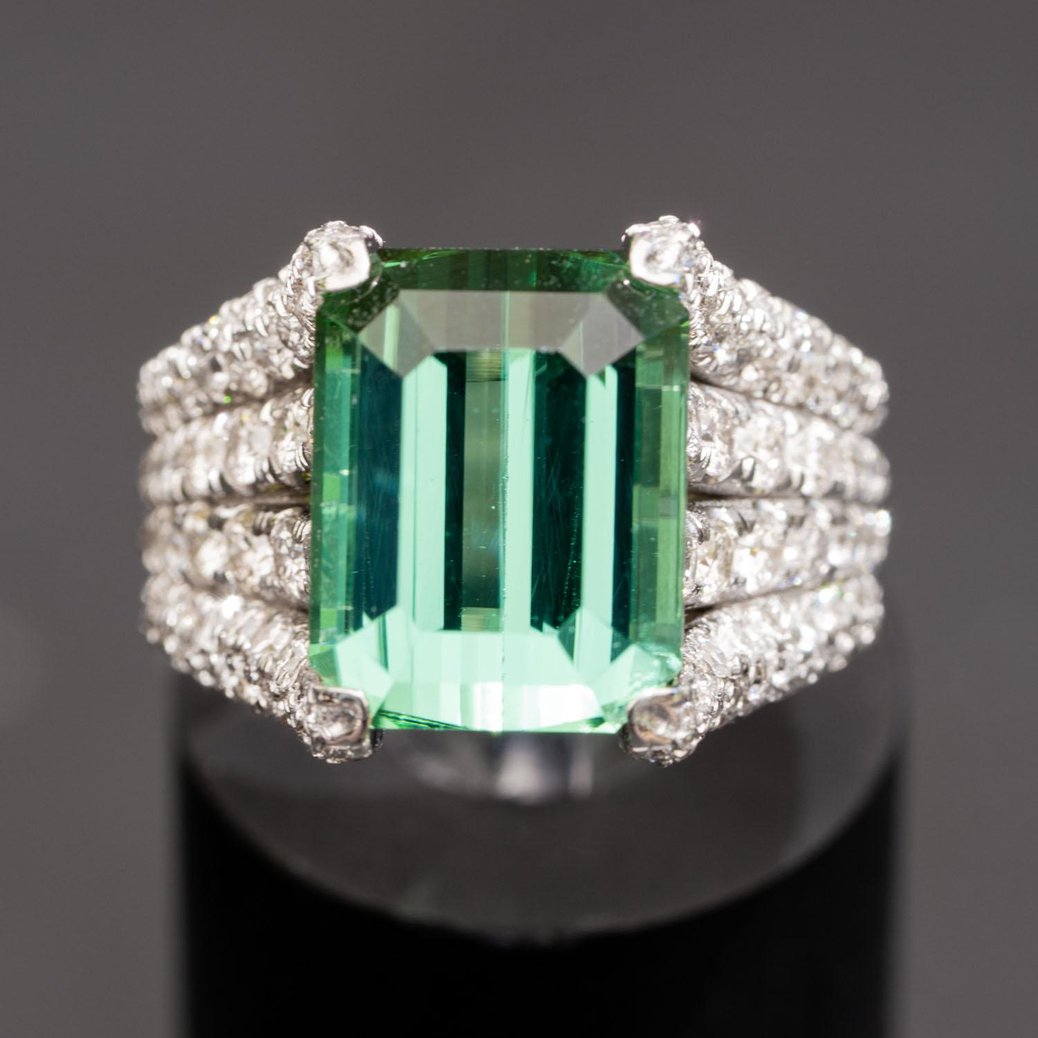 This 7.32 carat natural tourmaline diamond ring brings a lush touch of color to your fine jewelry collection, and surrounds it with 1.92 carats of natural VS sparkling diamonds along the outer band. The emerald shape of the large natural gem of the