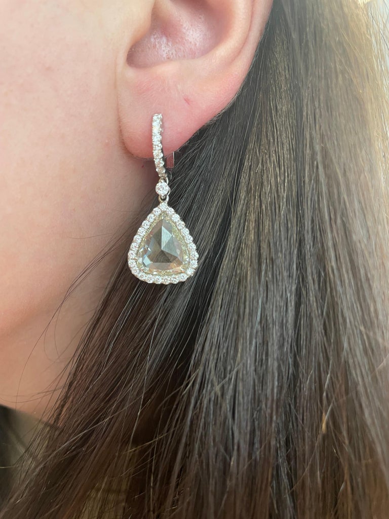 Unique modern pear shape rose cut diamond with halo drop earrings. High jewelry by Alexander Beverly Hills.
2 pear shape rose cut diamonds, 7.33 carats. Approximately K/L color and VS2/SI1 clarity. Complimented by 70 round brilliant diamonds, 1.35