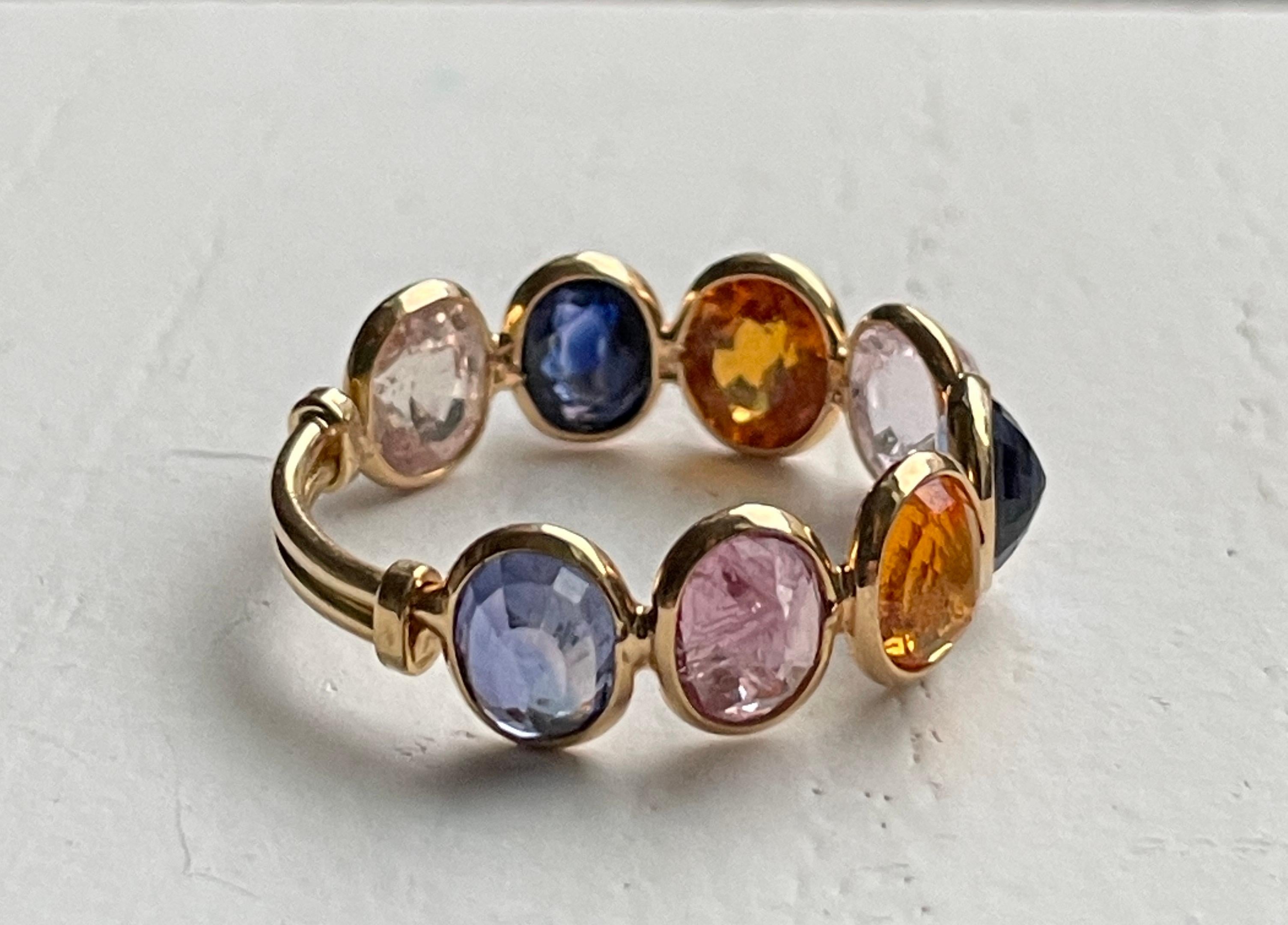 This gorgeous 18K Gold Ceylon Sapphire ring is comprised of 8 multi colored Ceylon sapphires ranging from light blue, light pink and amber. The stones are checkered cut and set upside down so that the peak of the stone faces up giving the ring