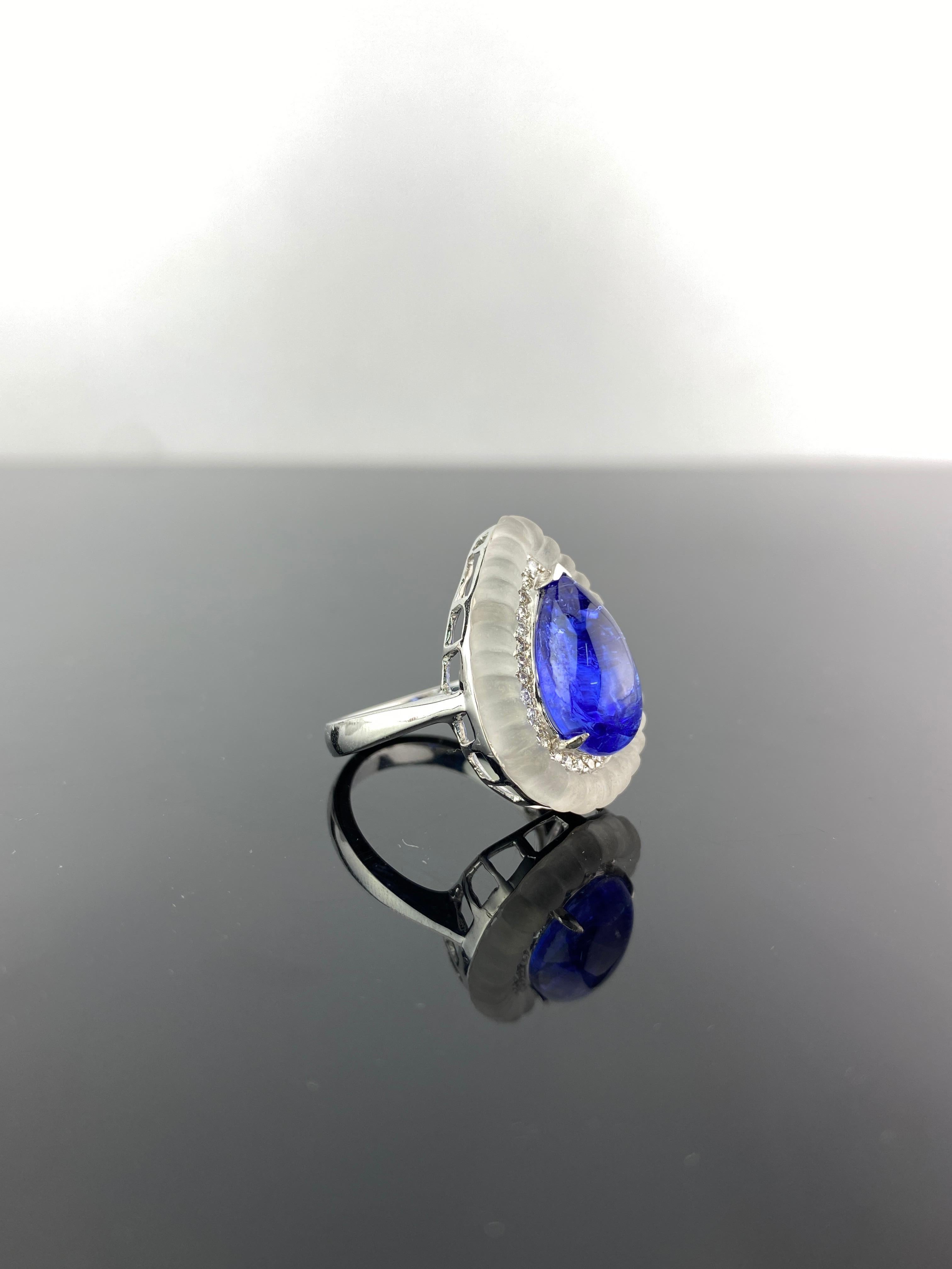 A art-deco looking, 7.35 carat pear shape cabochon Tanzanite, 0.36 carat Diamond and 5.53 carat Rock Crystal cocktail ring. The Tanzanite is transparent, with an ideal blue hue, and is set in 8.21 grams of solid 18K White Gold. Available in  pear