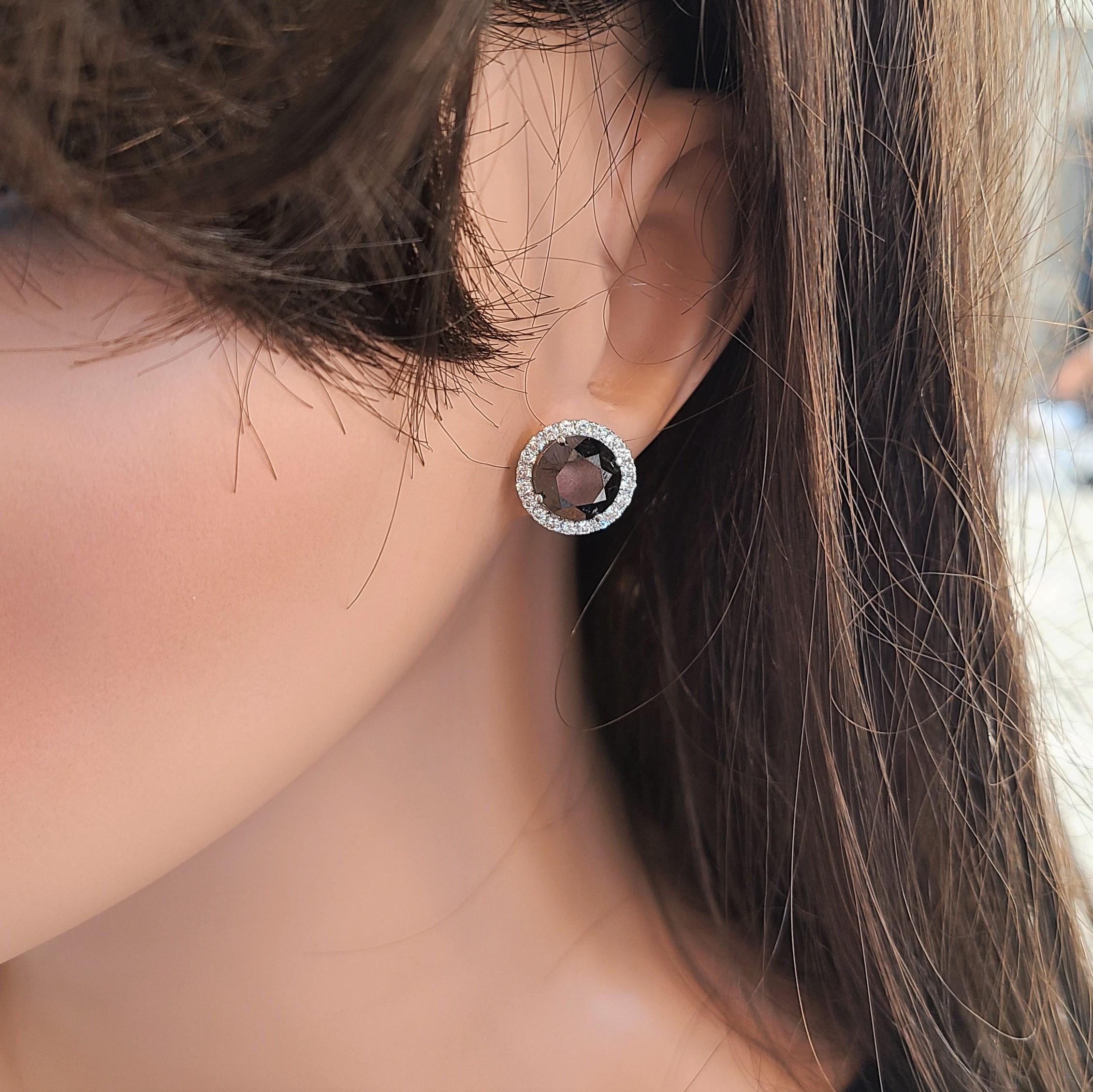 This pair of 7.39 carat total Black diamond stud earring and jackets are elegantly crafted in brightly polished 14 karat white gold and feature a total of 36 sparkling round brilliant cut diamonds. A total of 0.65 carat of diamonds adorn these