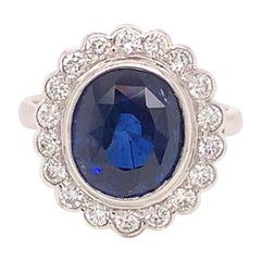 7,4 Karat halber ovaler blauer Saphir und Diamant-Cluster-Ring aus 18 Karat Weißgold