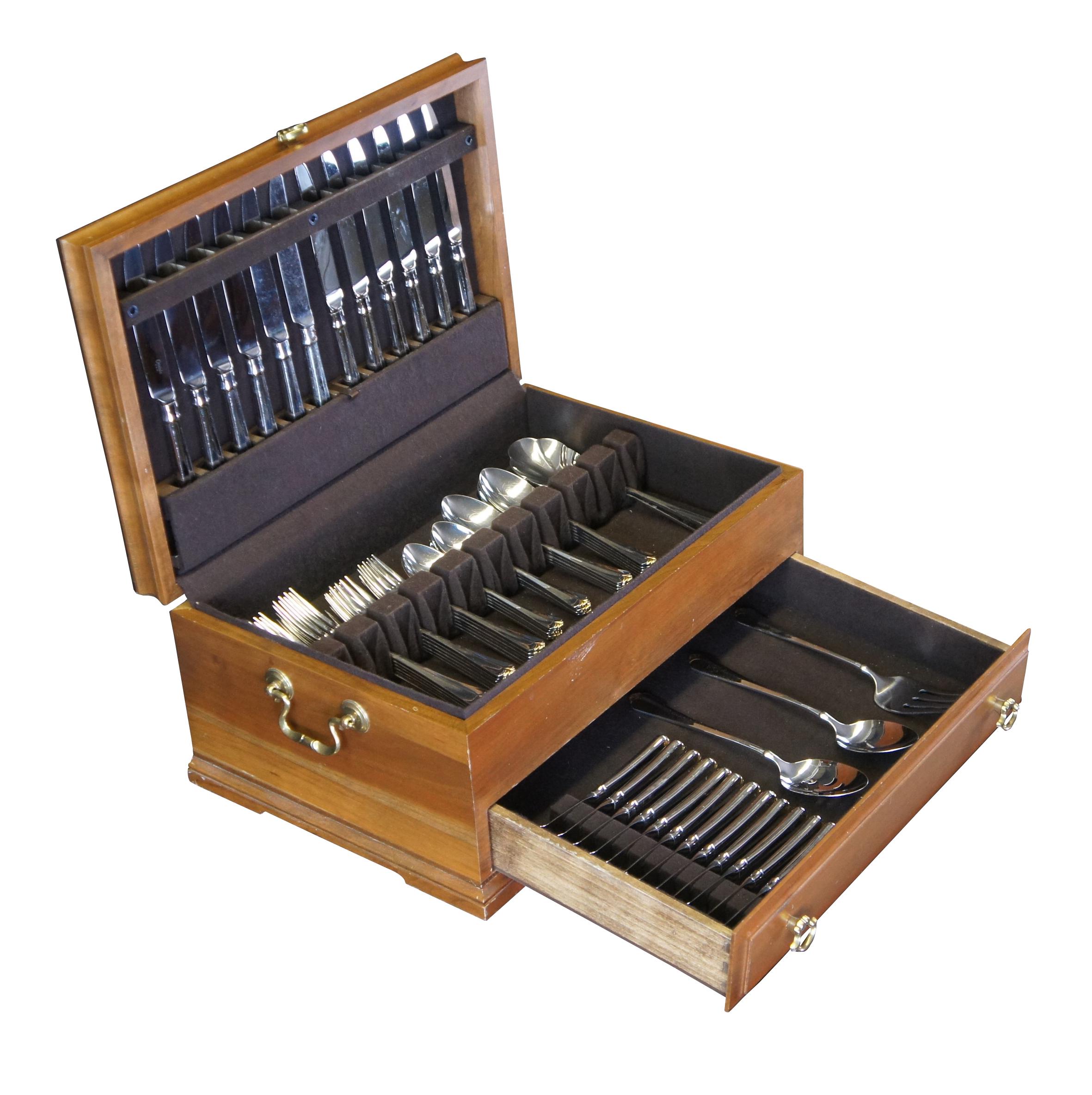 Oneida Golden Julliard, (stainless and gold accent), circa 1990s.  Includes a Mahogany case with dividers and drawer

Includes
12 dinner forks
12 salad forks
12 knives
11 spoons
10 teaspoons
12 butter knives
5 serving pieces

Dimensions:
box 18