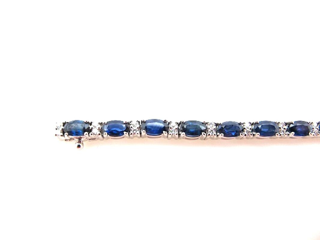 This gorgeous tennis bracelet features 24 royal blue sapphires set with brilliant white diamonds in 14k white gold. The sapphires have a rich blue color which shows up beautifully against the striking white gold. Two diamonds sit in-between the