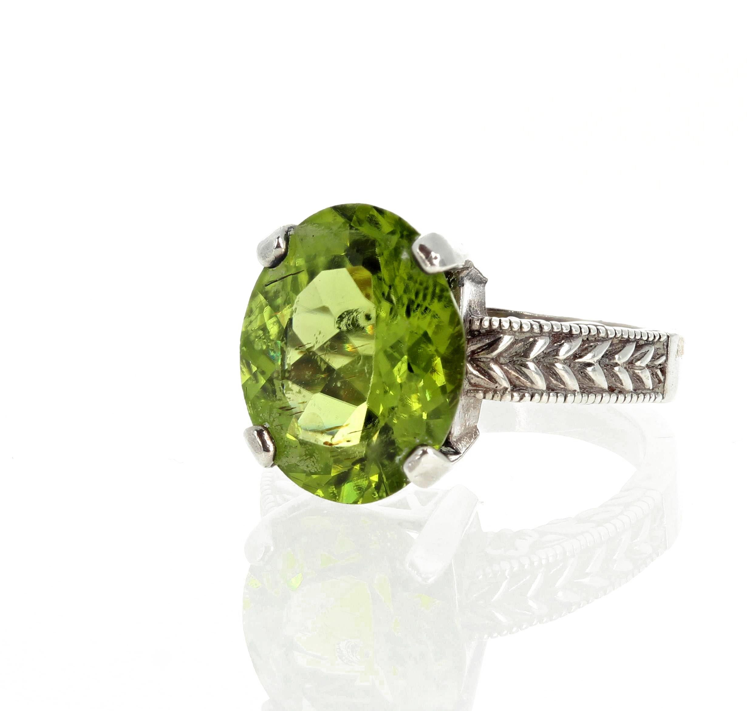 Beautiful glittering 7.43 carat Peridot (15mm x 12mm) set in a sterling silver ring size 7 (sizable).  Spectacular optical effect in the Peridot exhibits goldygreen reflections and fire highlights in spectral green colors and makes the gemstone