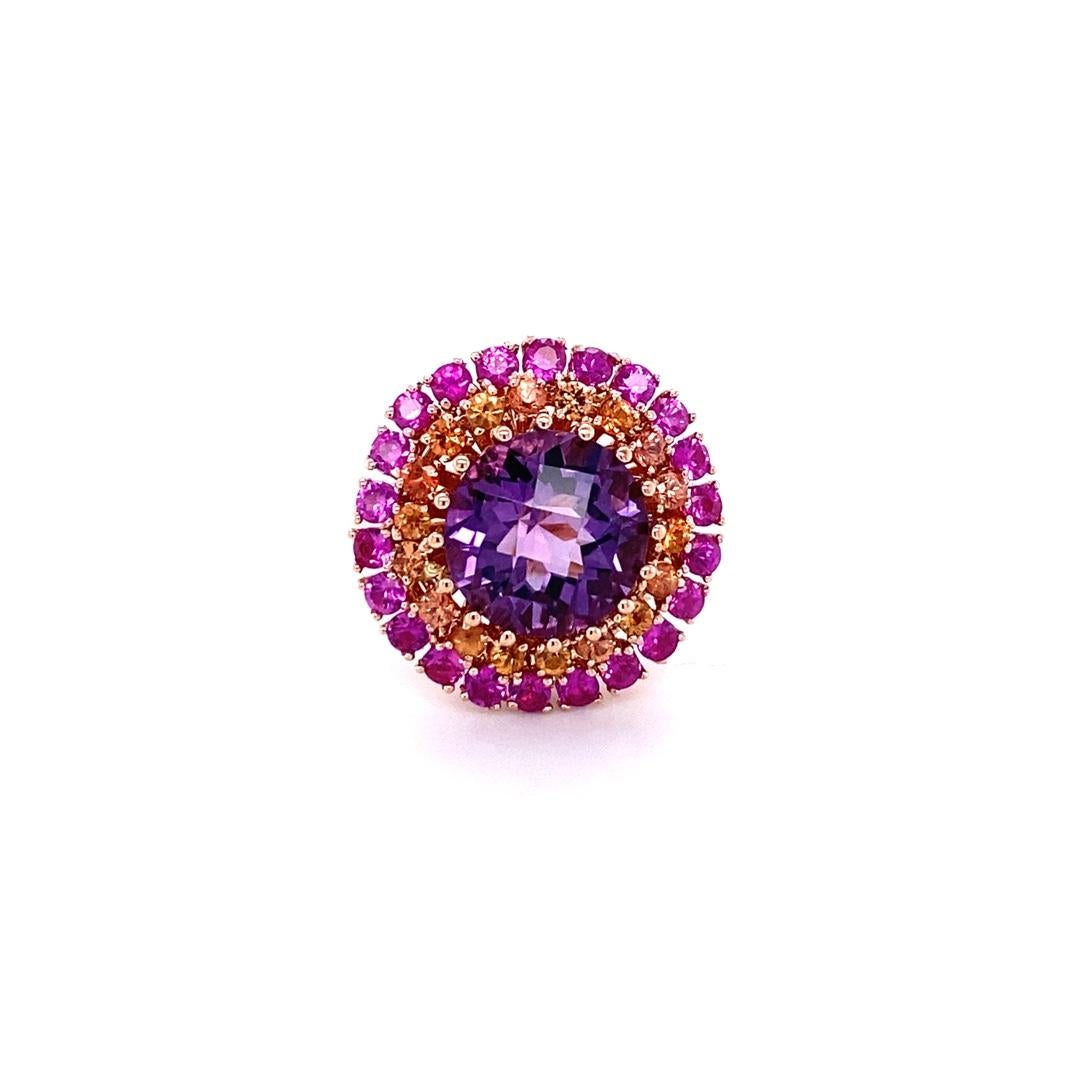 Beautiful and uniquely designed cocktail ring!
7.44 Carat Amethyst Sapphire 14K Rose Gold Cluster Ring

Item specs.:

Round Cut Amethyst: 5.15 cts.
18 Orange Sapphires: 0.80 ct.
22 Pink Sapphires: 1.49 cts.
Curated in 14K Rose Gold: 11.6 grams
Total