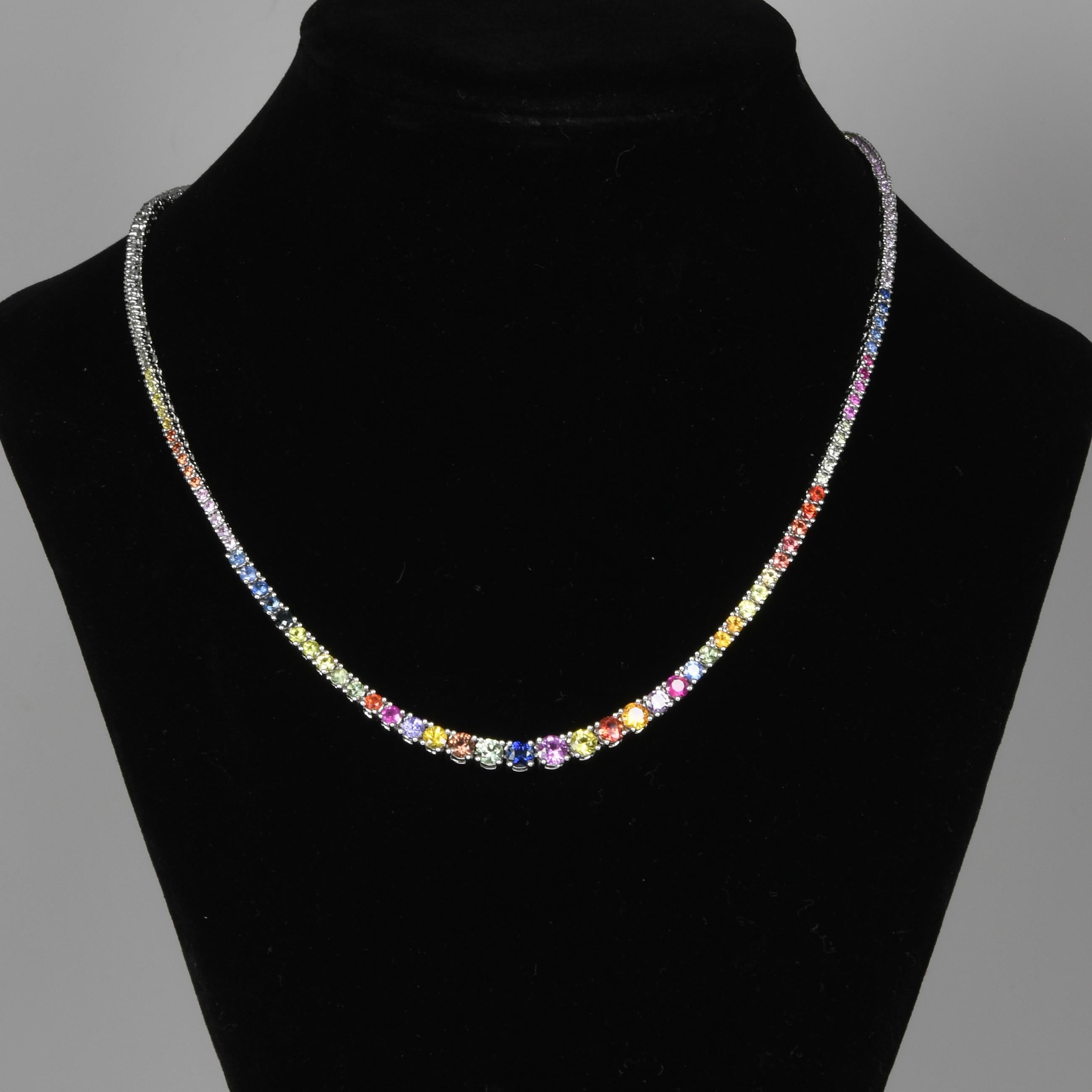 Diese exquisite Tenniskette zeigt einen Farbverlauf aus mehrfarbigen Regenbogensaphiren, die sorgfältig in glänzendes 14-Karat-Weißgold gefasst sind. Das abgestufte Design hebt ein atemberaubendes Spektrum an Farbtönen hervor, das von leuchtenden