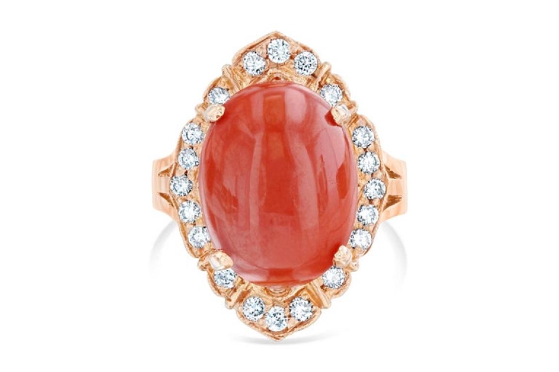 The Oval Cut Organic Coral is 7.02 Carats and is adorned by 20 Round Cut Diamonds weighing 0.46 Carats. The clarity and color of the diamonds are VS2-H. The Total Carat Weight of the ring is 7.48 Carats. The Coral measures at 15 mm x 11 mm.