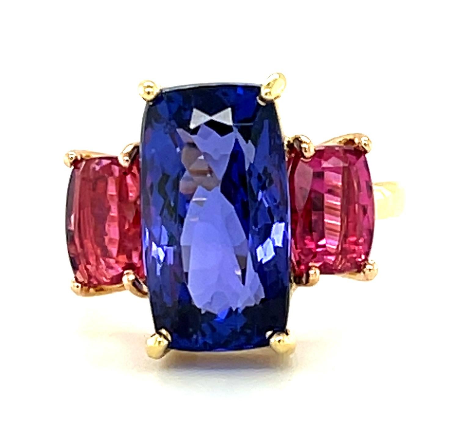Gemstones in beautiful, vibrant colors and custom shapes are what this modern version of the classic, 3-stone ring is all about! It features an elongated cushion cut tanzanite in a beautiful, deep, periwinkle color and a matched pair of deep fuchsia