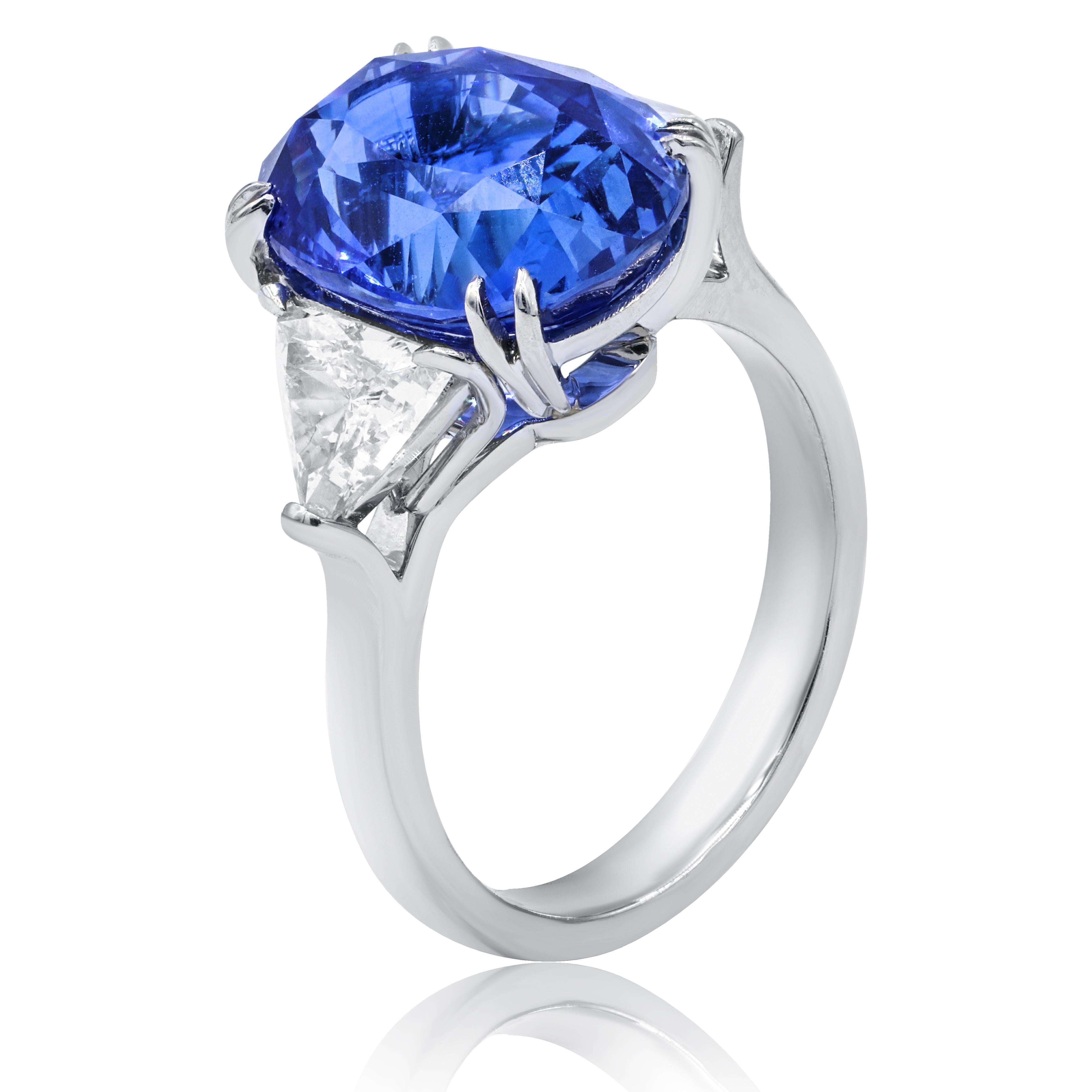 Platinum sapphire and diamond ring, features 7.48 ct oval sapphire set with two triangular brilliants 1.04ct