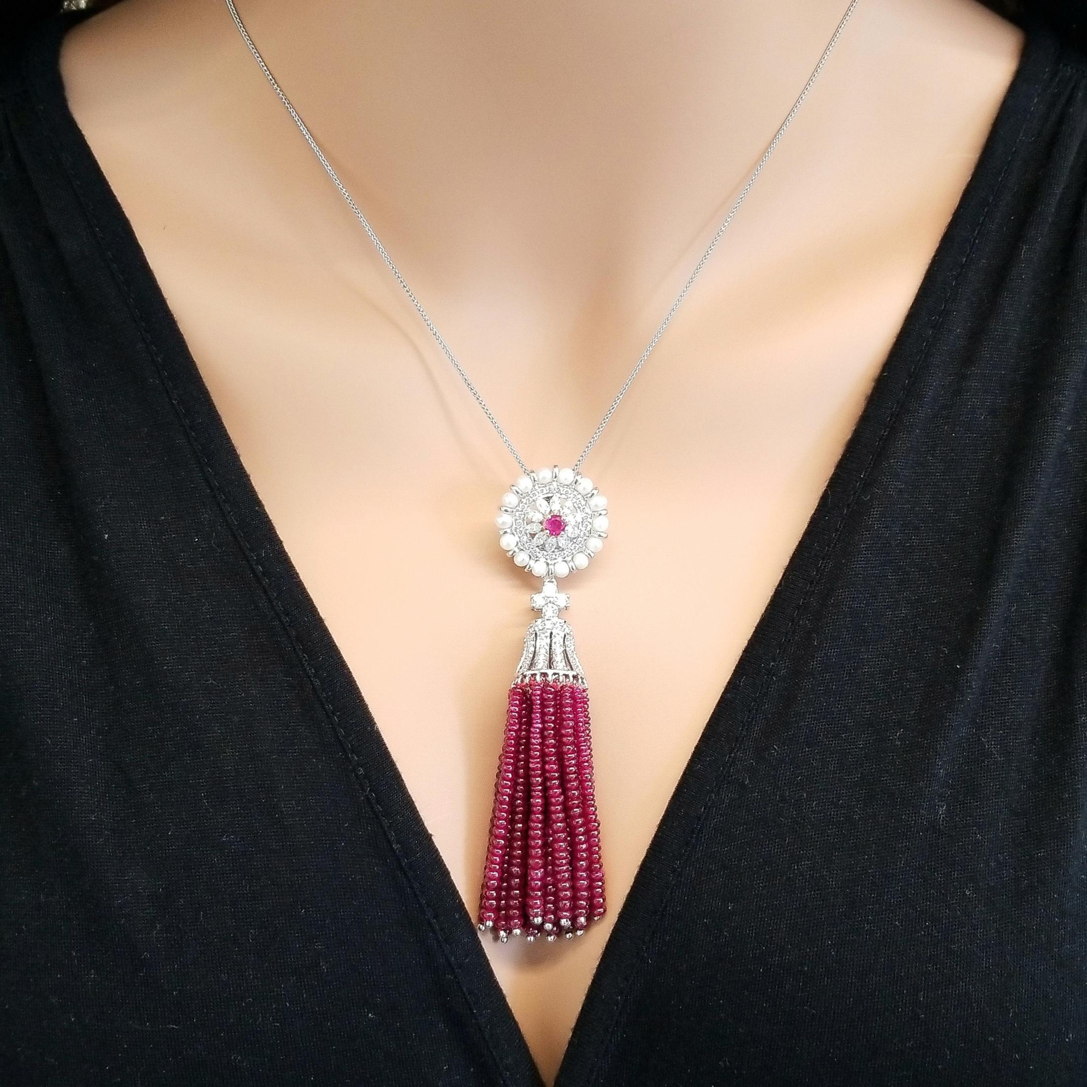 This pendant drips rubies. The ruby gem source is Thailand. 74.87 carats of ruby beads tassle is significant. Its blood red color is sought after and is perfectly, precisely matched. A total of 2.03 carats of sparkling round brilliant cut diamonds