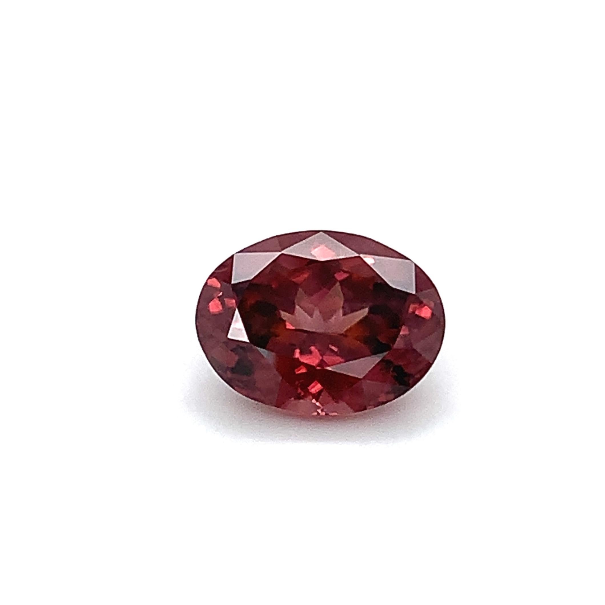 This pretty rose zircon is a perfectly symmetrical oval and has a beautiful medium reddish pink color. While zircon is widely recognized for its lovely blue shades, this December birthstone actually occurs in a rainbow of colors and has been prized