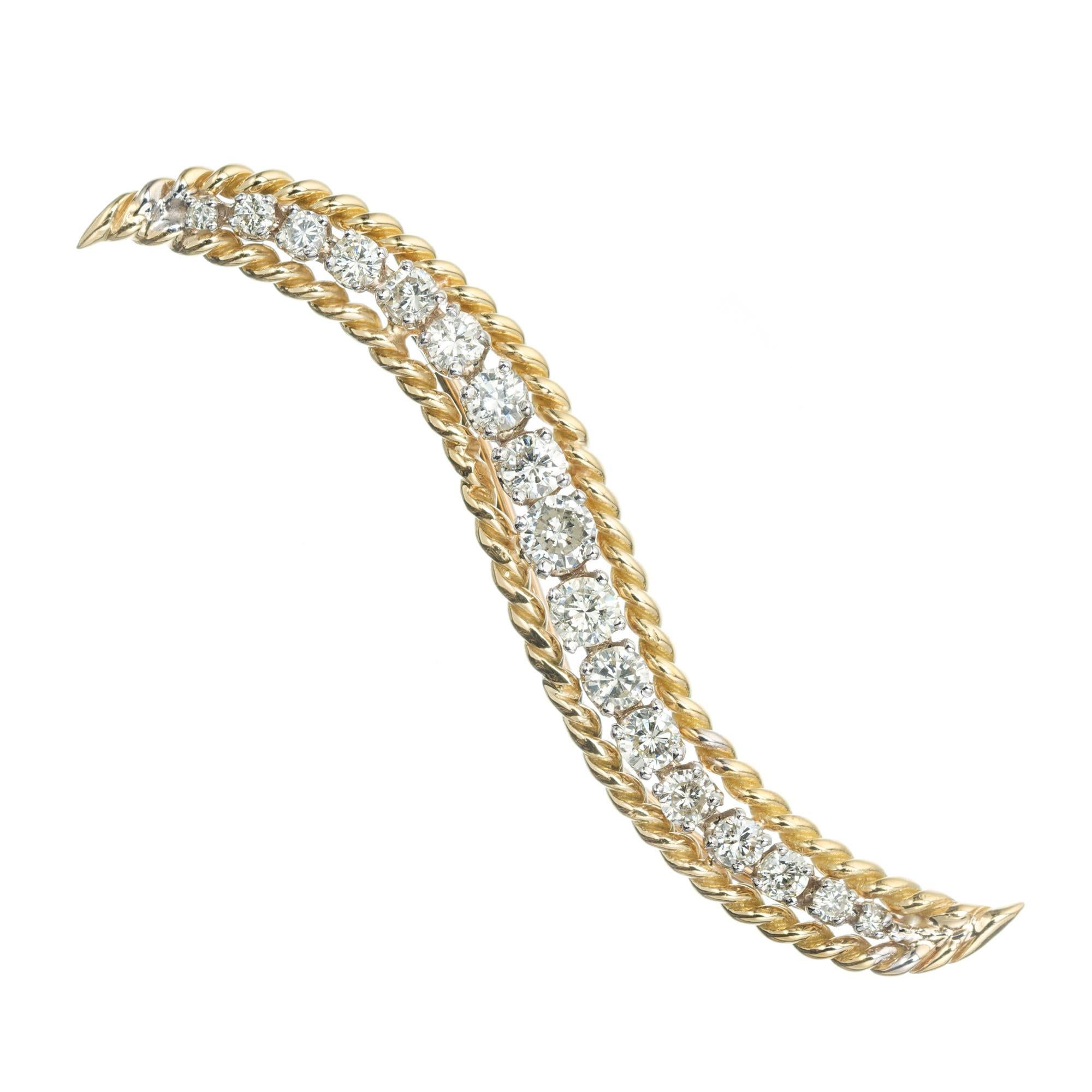 18k yellow gold and platinum, Swirl brooch with 17 round graduated diamonds. 

17 round diamonds, I SI2 approx. .75cts
18k yellow gold 
Platinum 
5.1 grams
Top to bottom: 10.4mm or .40 Inches
Width: 51.3mm or 2 Inches
Depth or thickness: 3.9mm
