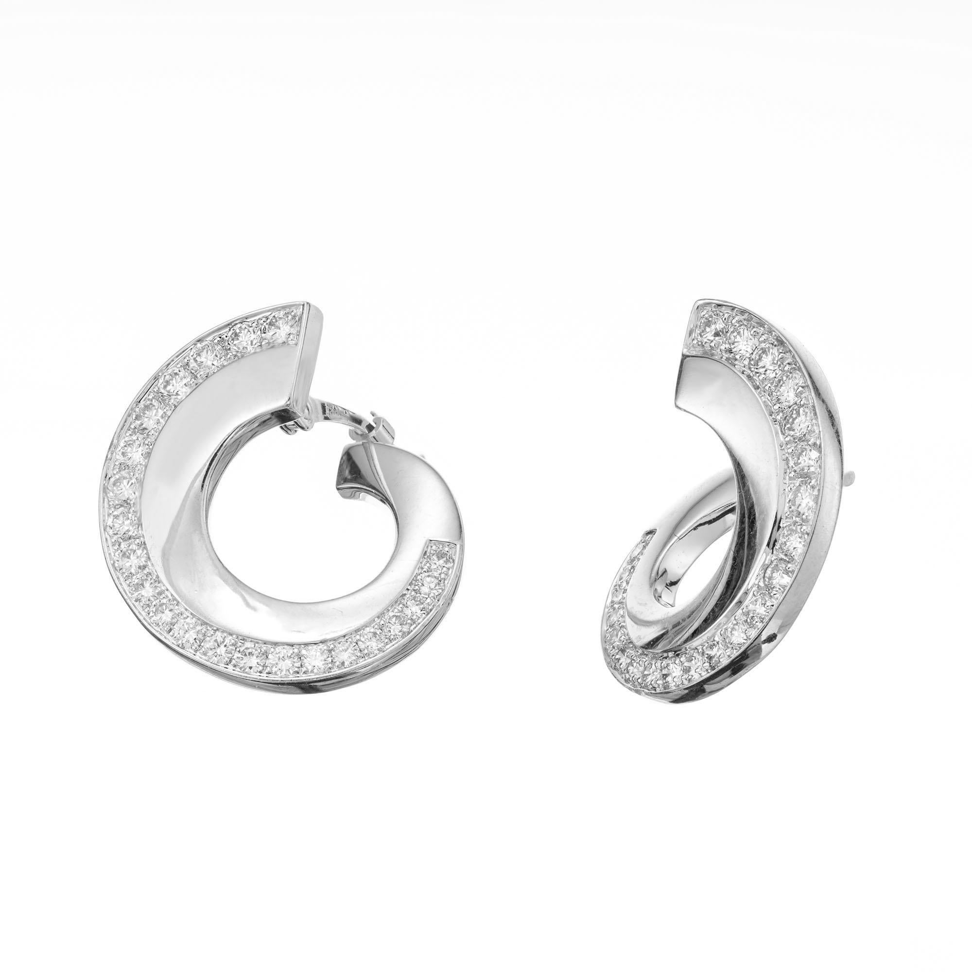 Swirl 18k white gold front to back diamond hoop earrings with hinged posts. 44 round full cut diamonds. 

44 round full cut diamonds, approx. total weight .75cts, F, VS
18k white gold
Tested: 18k
Stamped: 750
6.5 grams
Top to bottom: 17.88mm or .70