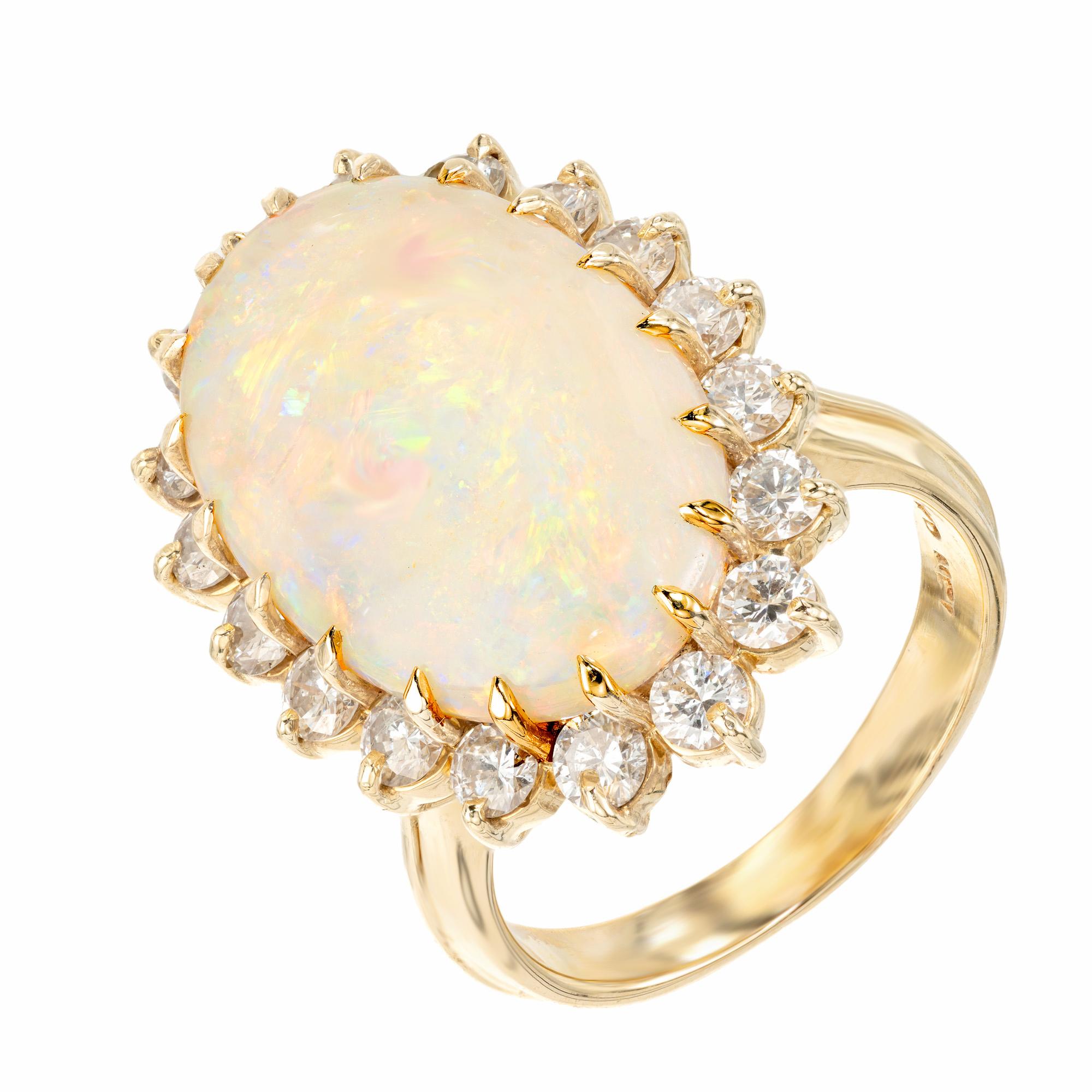 Beautiful Australian opal and diamond cocktail ring. Intricately designed and breathtakingly radiant, the 7.50ct Australian oval opal is mounted in a 14k yellow gold setting, accentuated by a halo of 18 dazzling round brilliant cut diamonds. The