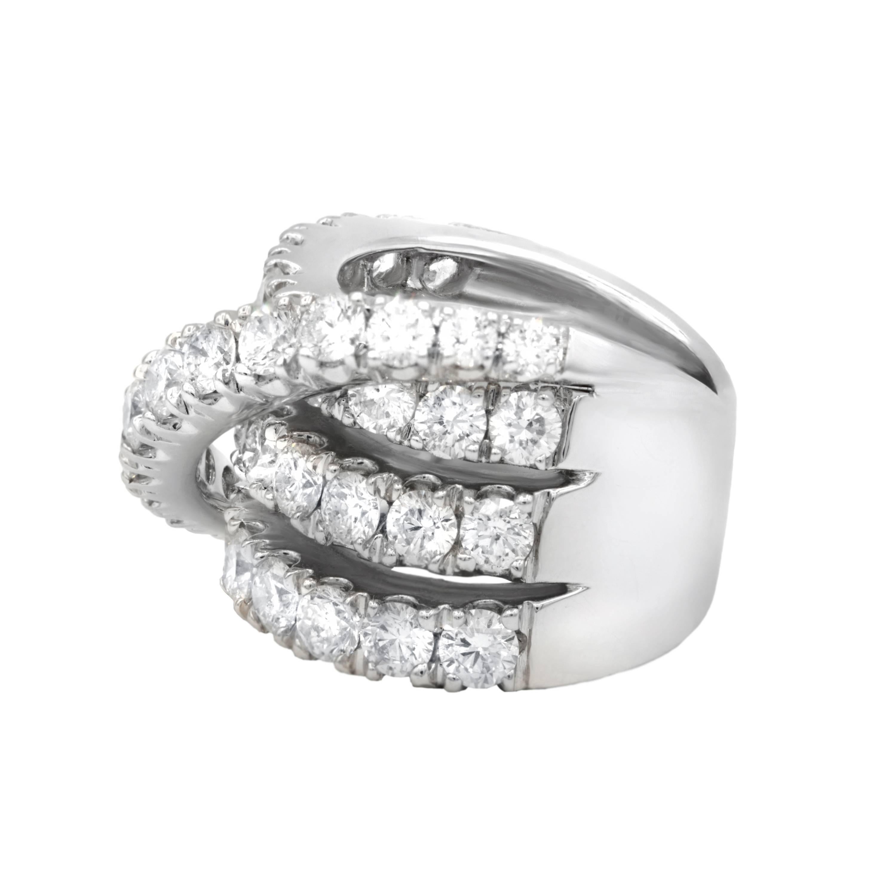 18 karat white gold fancy diamond ring consisting of 7.50 TCW round brilliant cut diamonds FG color/VS SI clarity  and set as 3 rows and cross with one row.