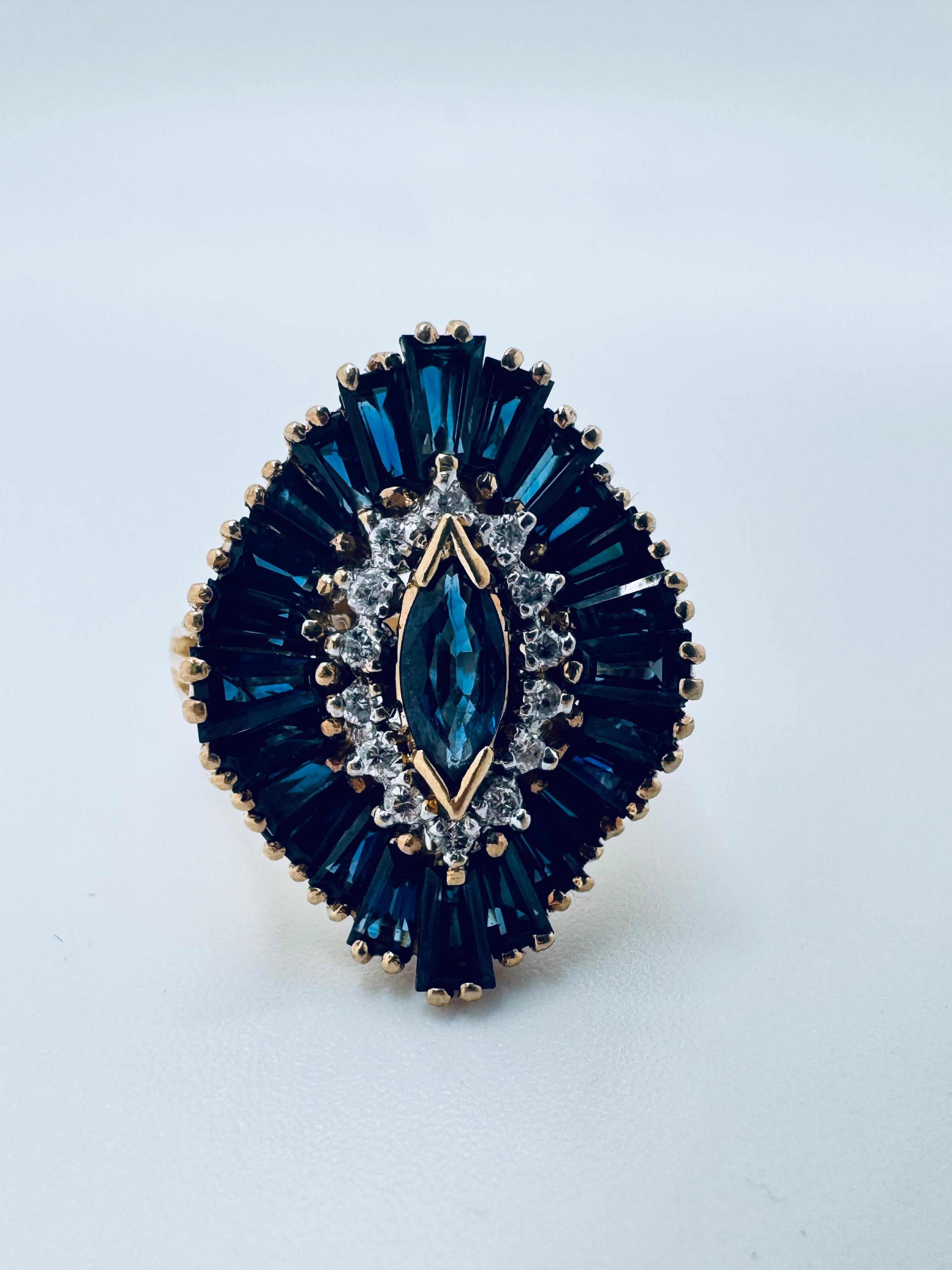 Réalisée en or jaune 750, cette bague de cocktail étonnante présente un arrangement vibrant de saphirs bleus et de diamants étincelants. Le modèle comporte environ 30 saphirs bleus de taille baguette, chacun soigneusement serti pour créer une