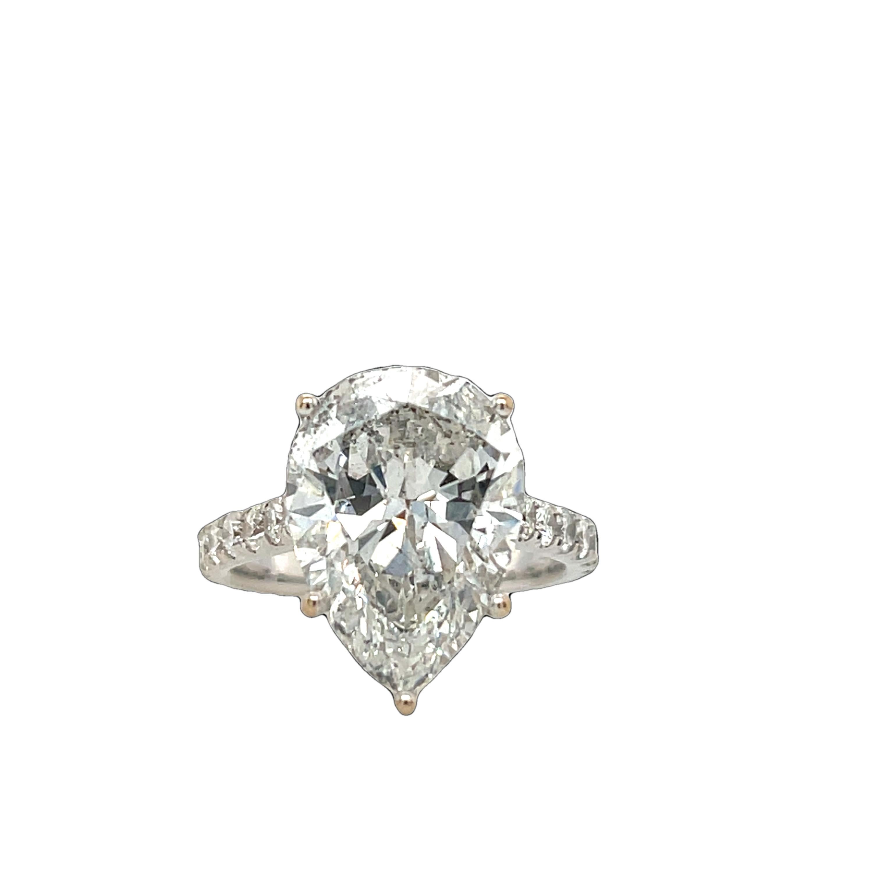 Un époustouflant diamant poire de 7,50 ct serti dans un luxueux or blanc 18 ct, complété par des diamants ronds de 0,65 ct de taille brillant ornant les épaules. 
Cette bague de déclaration offre un éclat et une élégance exceptionnels, ce qui en