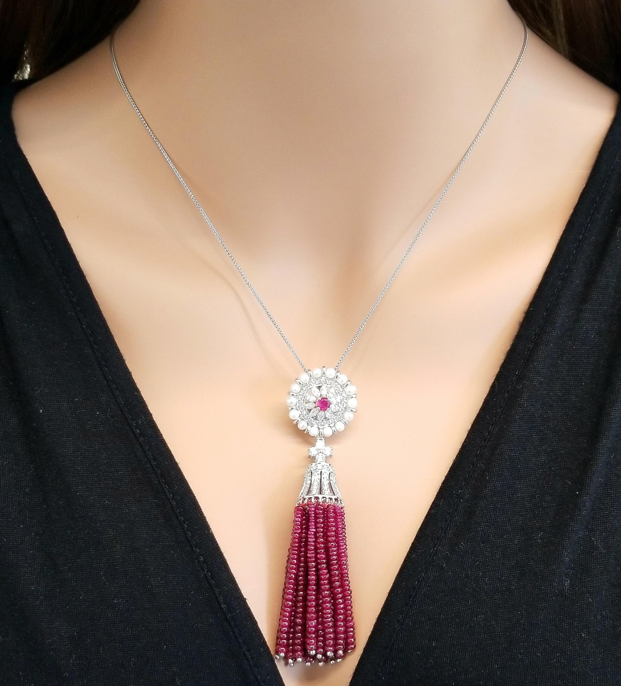 This pendant drips rubies. The ruby gem source is Thailand. 75.13 carats of ruby beads tassle is significant. Its blood red color is sought after and is perfectly, precisely matched. A total of 1.98 carats of sparkling round brilliant cut diamonds