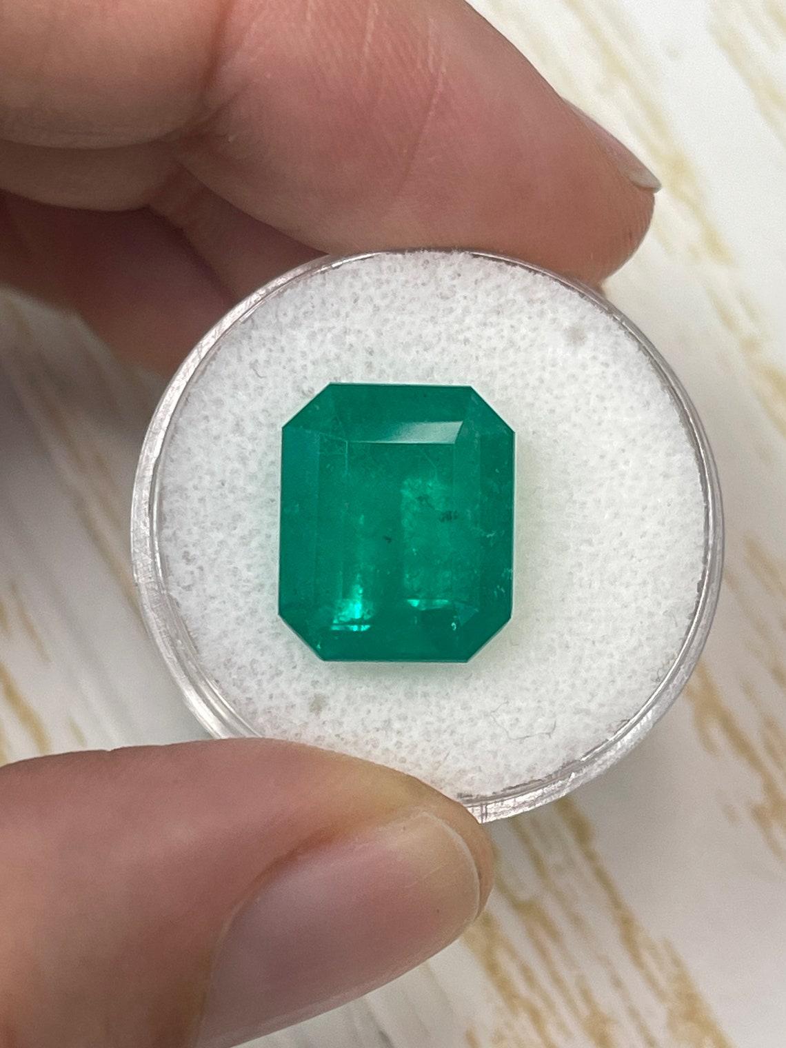 Stone: Emerald
Weight: 7.51-carats
Shape: Emerald Cut
Clarity: Semi-Transparent
Luster: Very Good
Color: Deep Forest Green
Measurements: 13.46mm x 11.23mm x 7.54mm
Geographic Origin: Colombia
Treatment: Natural, Oiling

Comments: Due to their growth