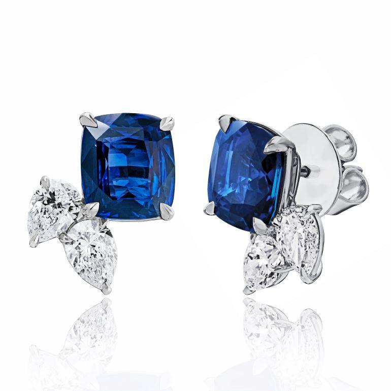 Zafiro azul en cojín (H) de 7,56 quilates con dos diamantes pera de 1,62 quilates engastados en unos pendientes de platino hechos a mano