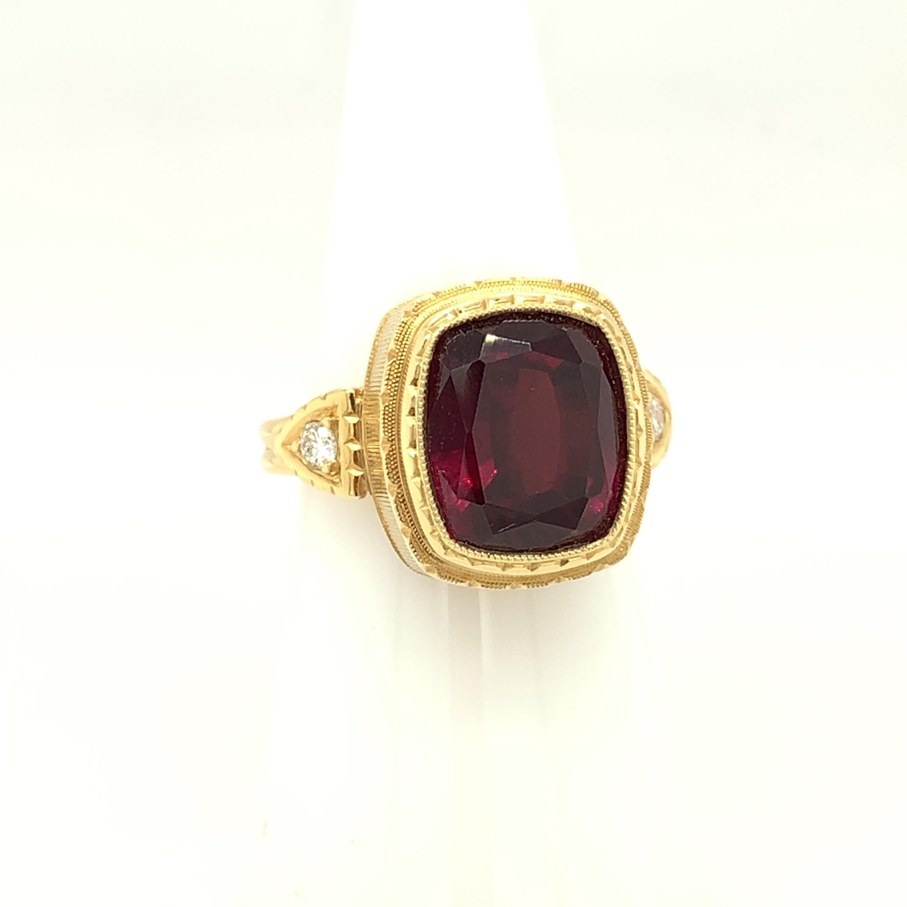 This engraved bezel ring features a 7.56 carat, rich port-wine color rhodolite garnet and sparkling diamonds in a handmade 18k yellow gold design. This setting was custom made for this fine gemstone and shows off the rhodolite's beautiful pinkish
