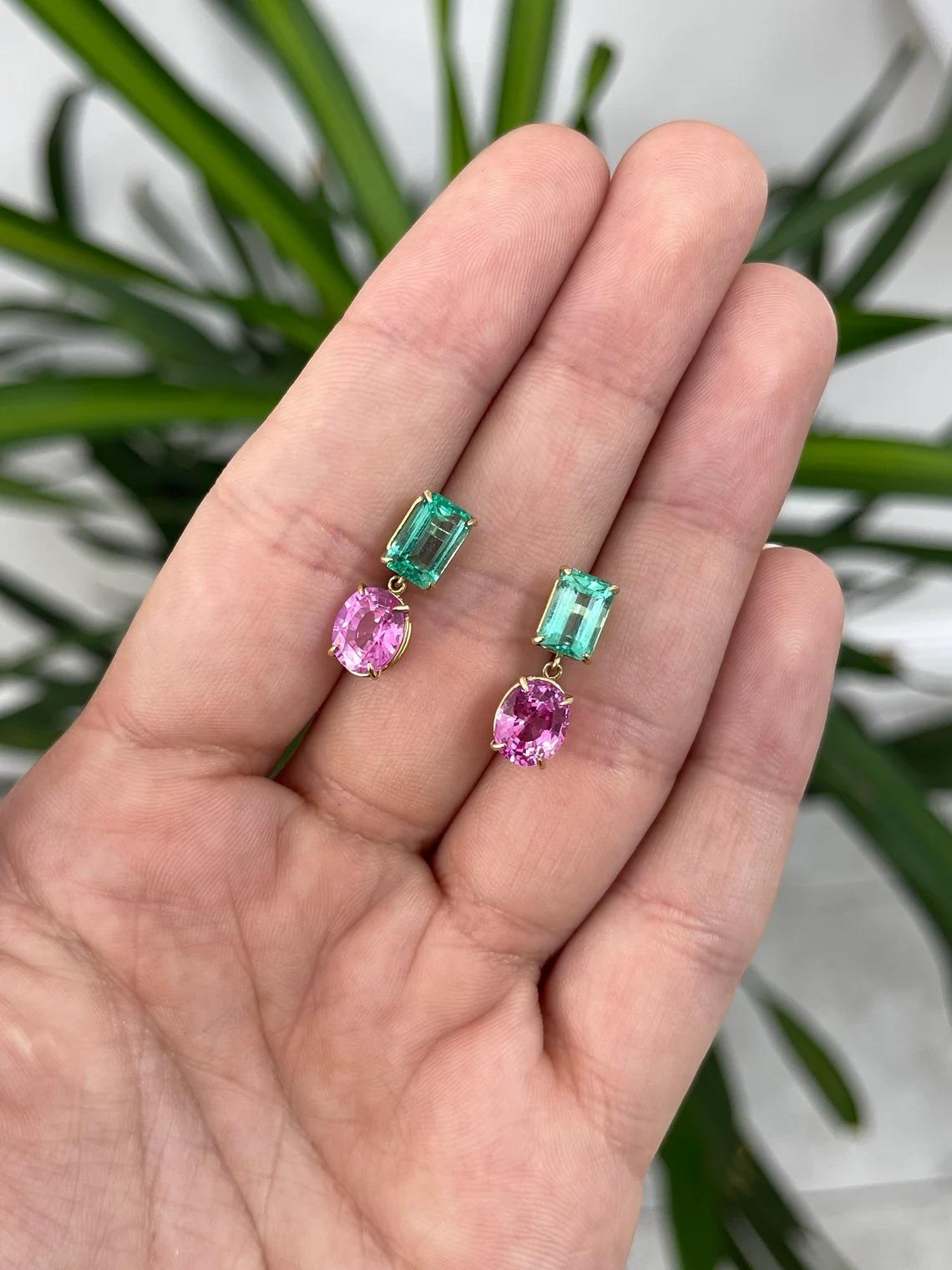 A remarkable pair of natural emerald and pink sapphire dangle earrings. Starting at the top we have a stunning pair of natural Colombian emerald cut emeralds; showcasing a vivid electric green color, excellent luster, and clarity. Dangling are two