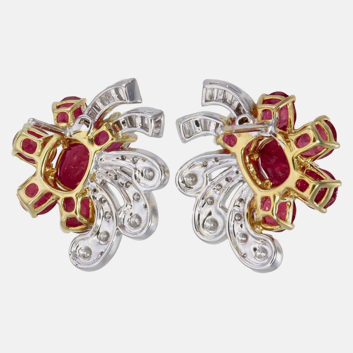 Un'elegante coppia di  Gli orecchini con rubini e diamanti di REWA Jewell sono realizzati in oro bianco 18 carati.

Il pezzo centrale è in legno naturale non trattato.  rubini birmani di forma ovale del peso di circa 2,48 carati. Circondato da 10