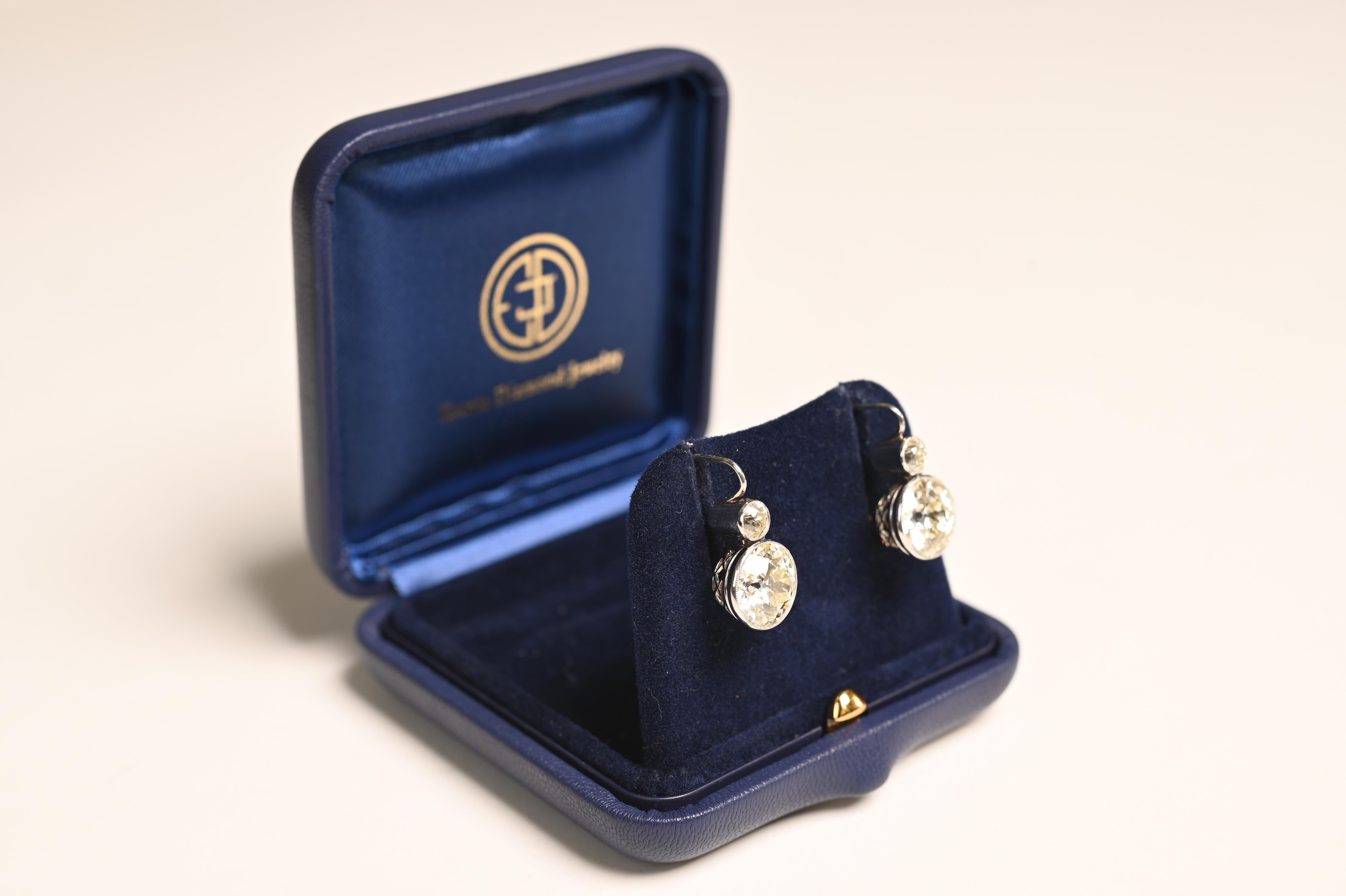 Presenting a magnificent pair of Old European Cut Diamond Earrings, expertly set in a meticulously handcrafted platinum mounting. These earrings showcase a remarkable blend of vintage charm and modern sophistication. The bottom diamonds possess a