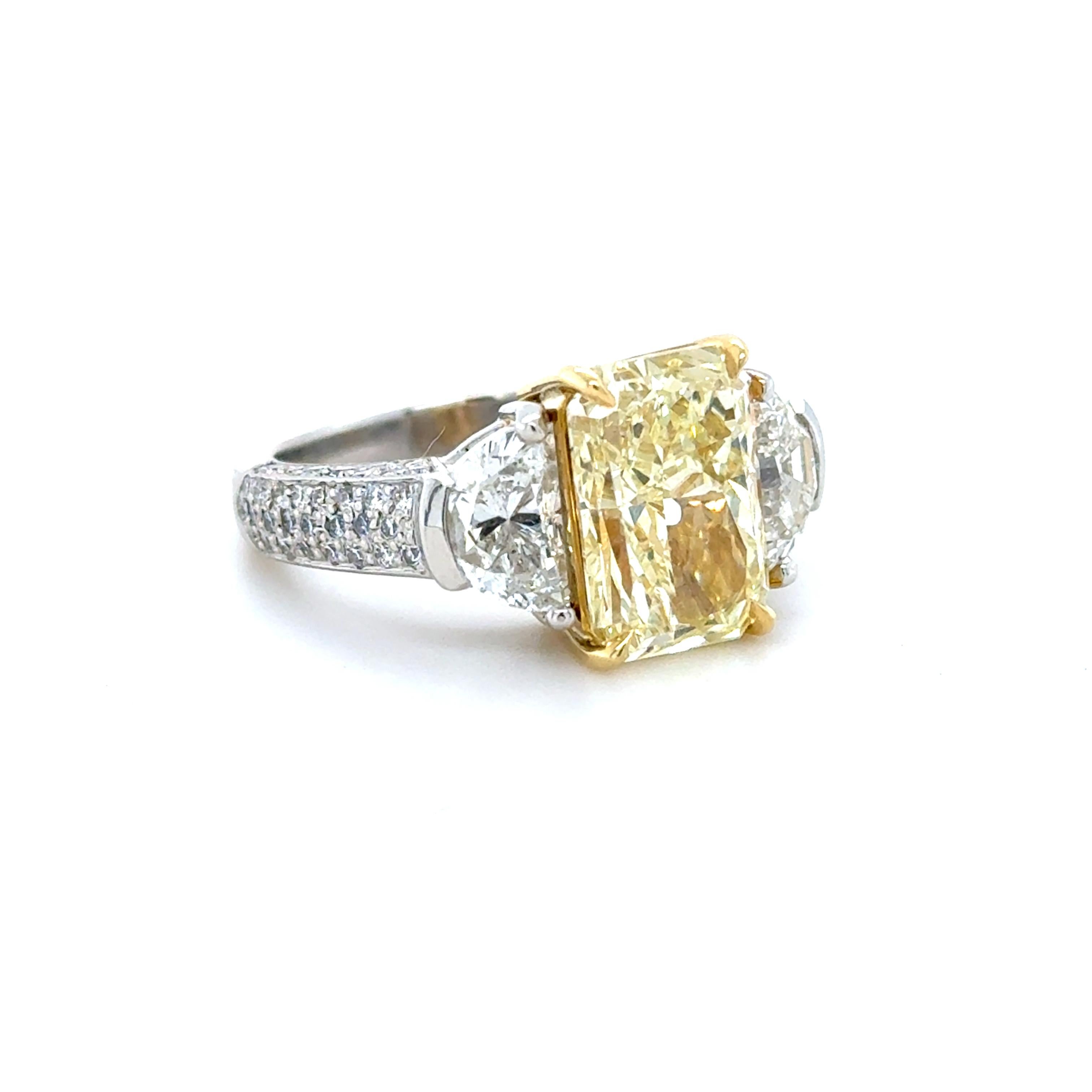 Cette magnifique bague est ornée d'un diamant de taille radieuse pesant 4,62 carats, flanqué de deux diamants de taille demi-lune pesant environ 1,65 carat et de diamants ronds de taille brillant le long de la tige, pesant au total environ 1,32