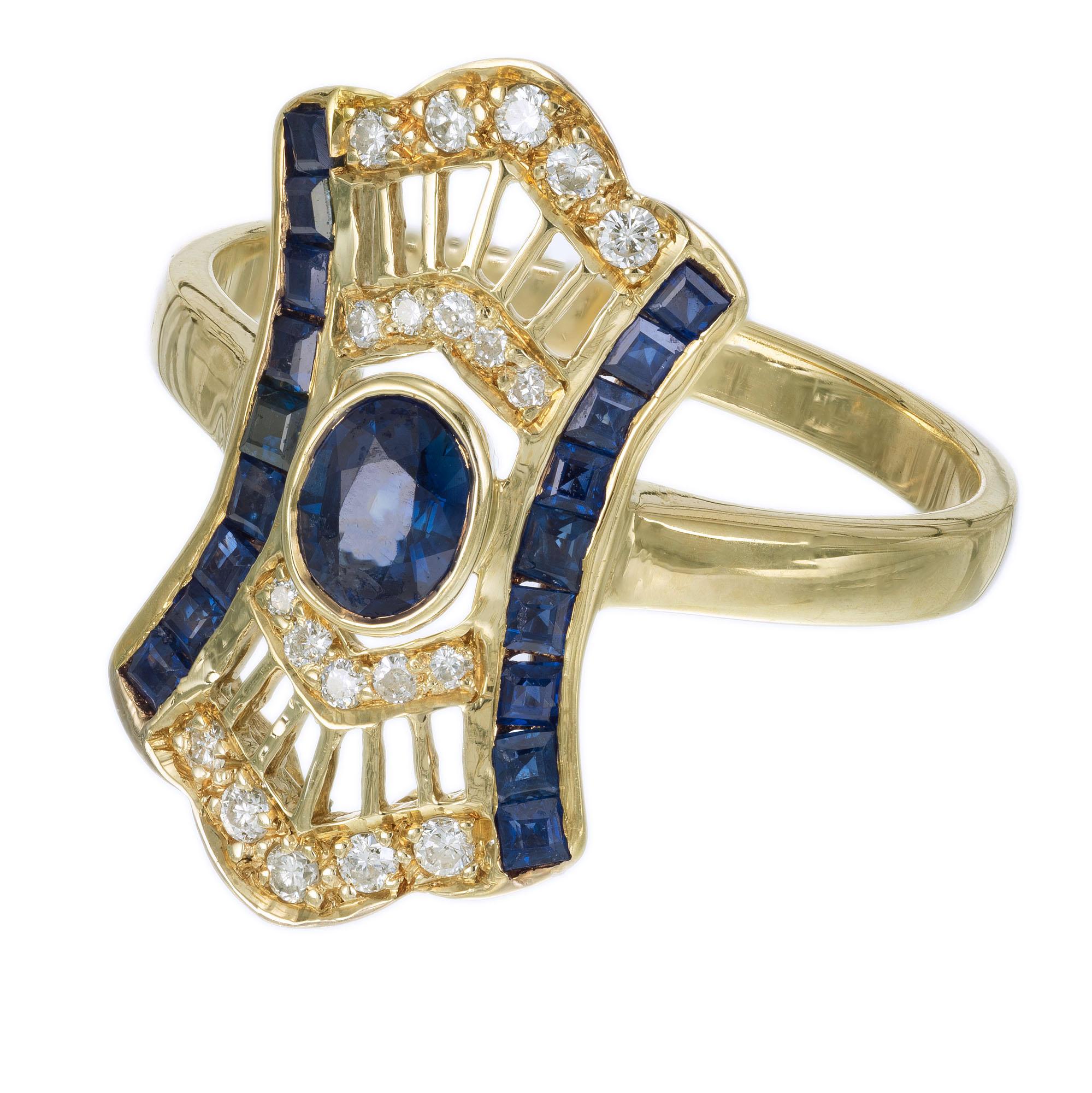 1950's Antique Inspired sapphire and diamond cocktail ring. Oval center sapphire in a 14k yellow gold setting with 38 round and step cut accent diamonds. 

1 oval blue sapphire SI, approx. .40cts
18 step cut square blue sapphires SI, approx.