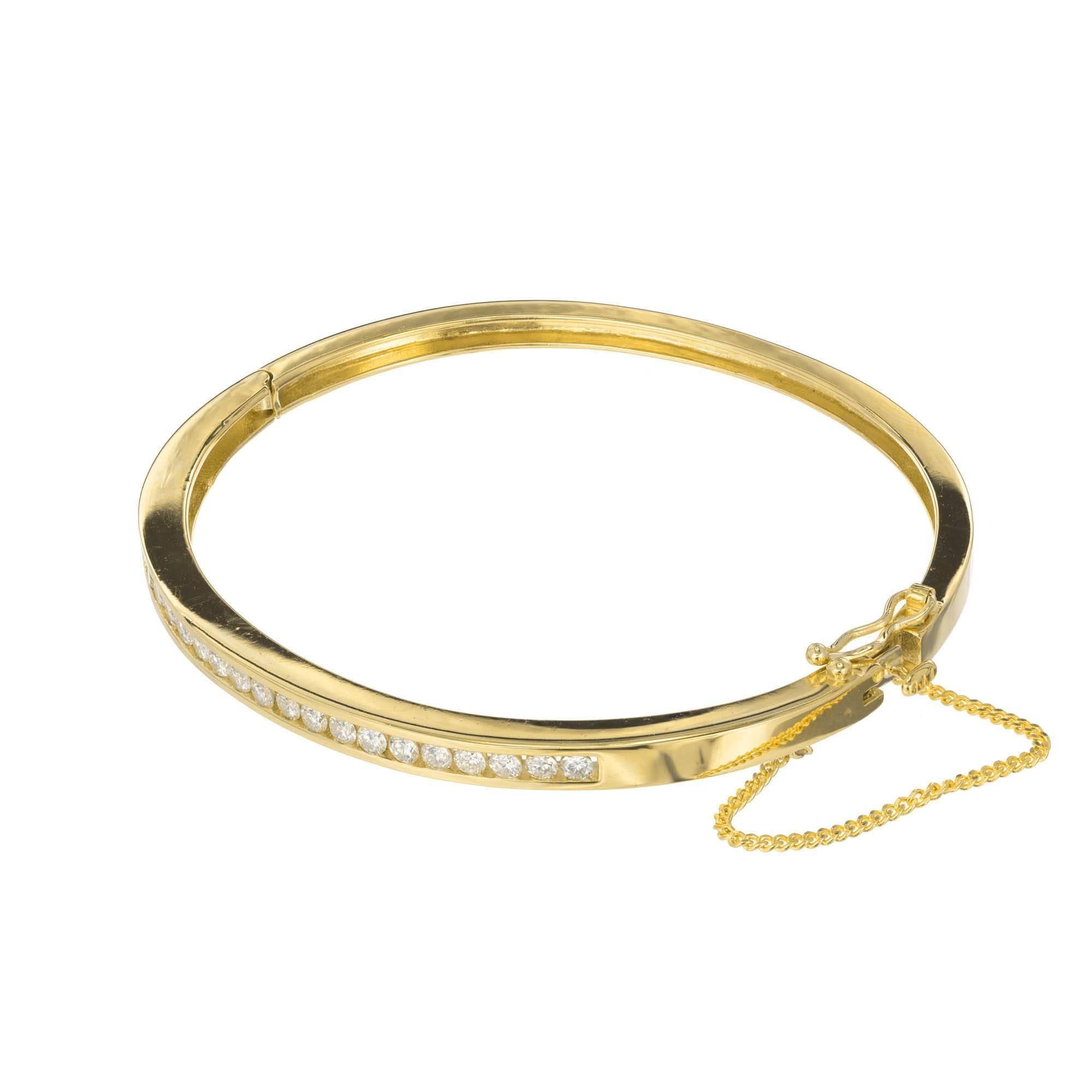 14k yellow gold diamond bangle bracelet. 19 round brilliant cut diamonds are channel set across the top half of the bangle. A safety chain is also attached at lock.

19 round G-H I diamonds 2.1-2.35mm Approximate .76 carats
14k yellow gold
Tested: