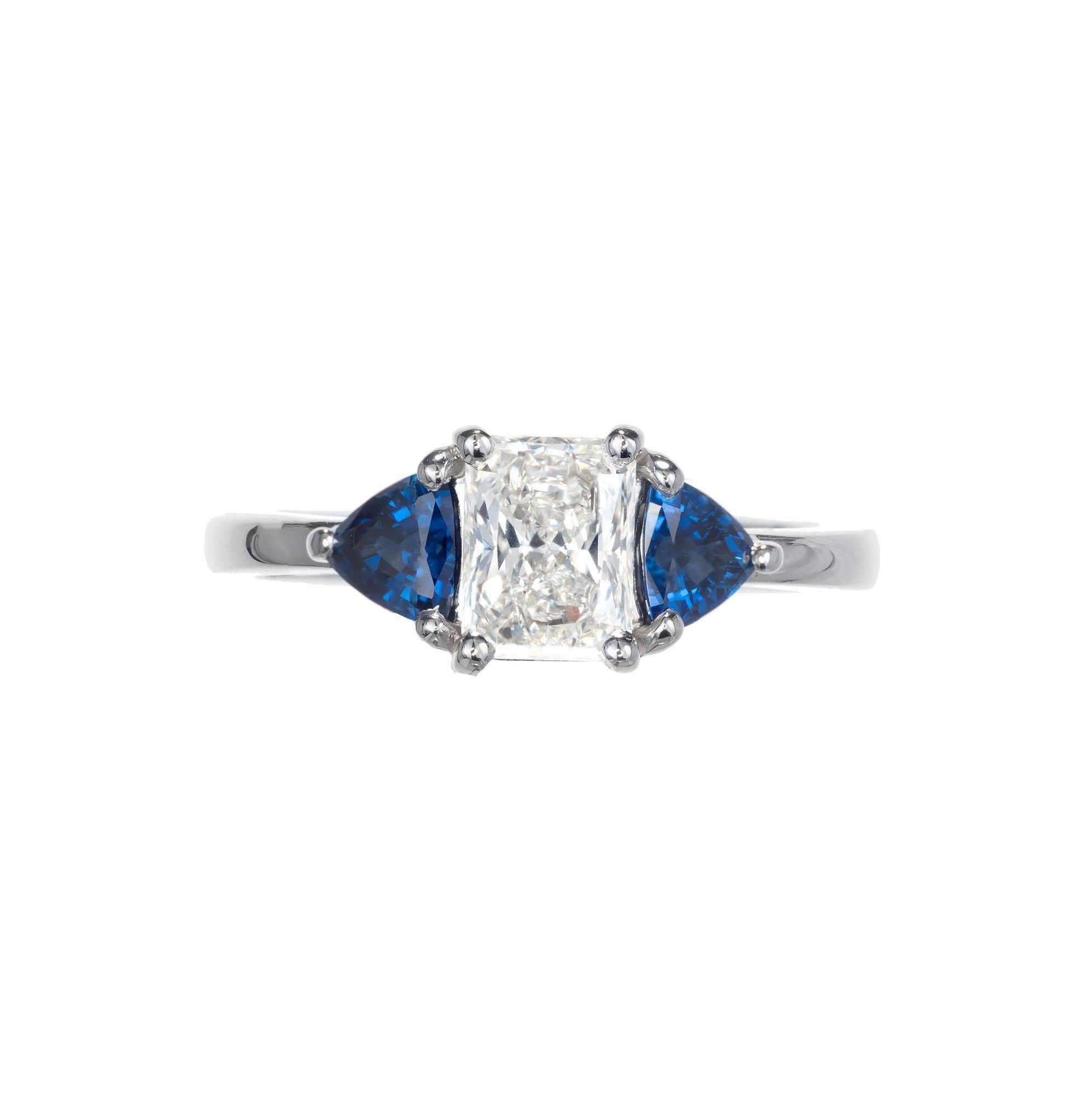 Diamond and sapphire three stone engagement ring. Set in platinum. Center cut-cornered rectangular modified brilliant stone with beautiful triangular brilliant cut blue sapphires on either side.

1 cut cornered rectangular modified brilliant I- VS2