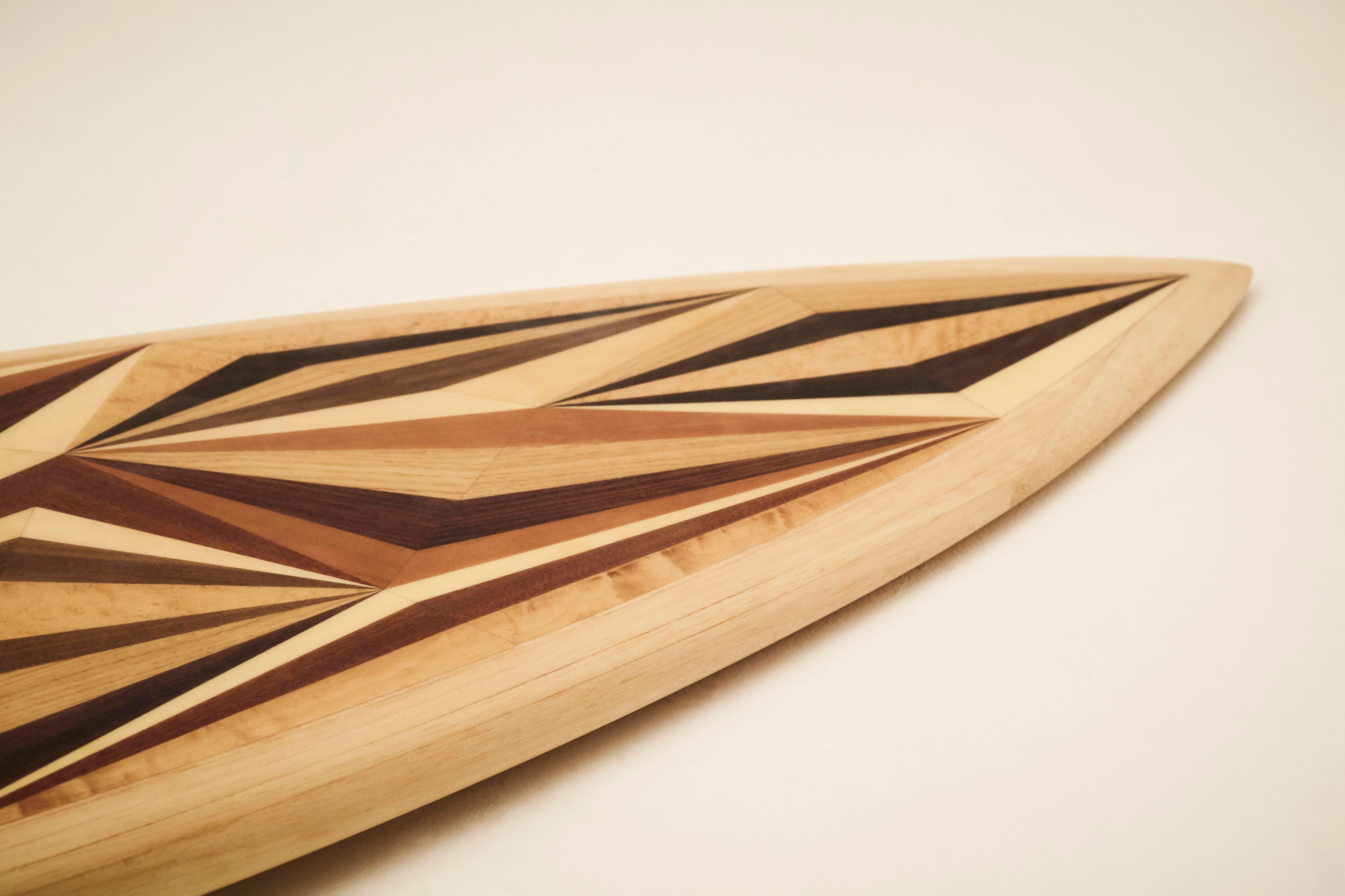 This is a unique custom surfboard featuring a marquetry deck, designed and hand-crafted by the w o o d p o p studio which specialises in marquetry and inlay work. 

The studio prides itself on constantly challenging the limits of where and how
