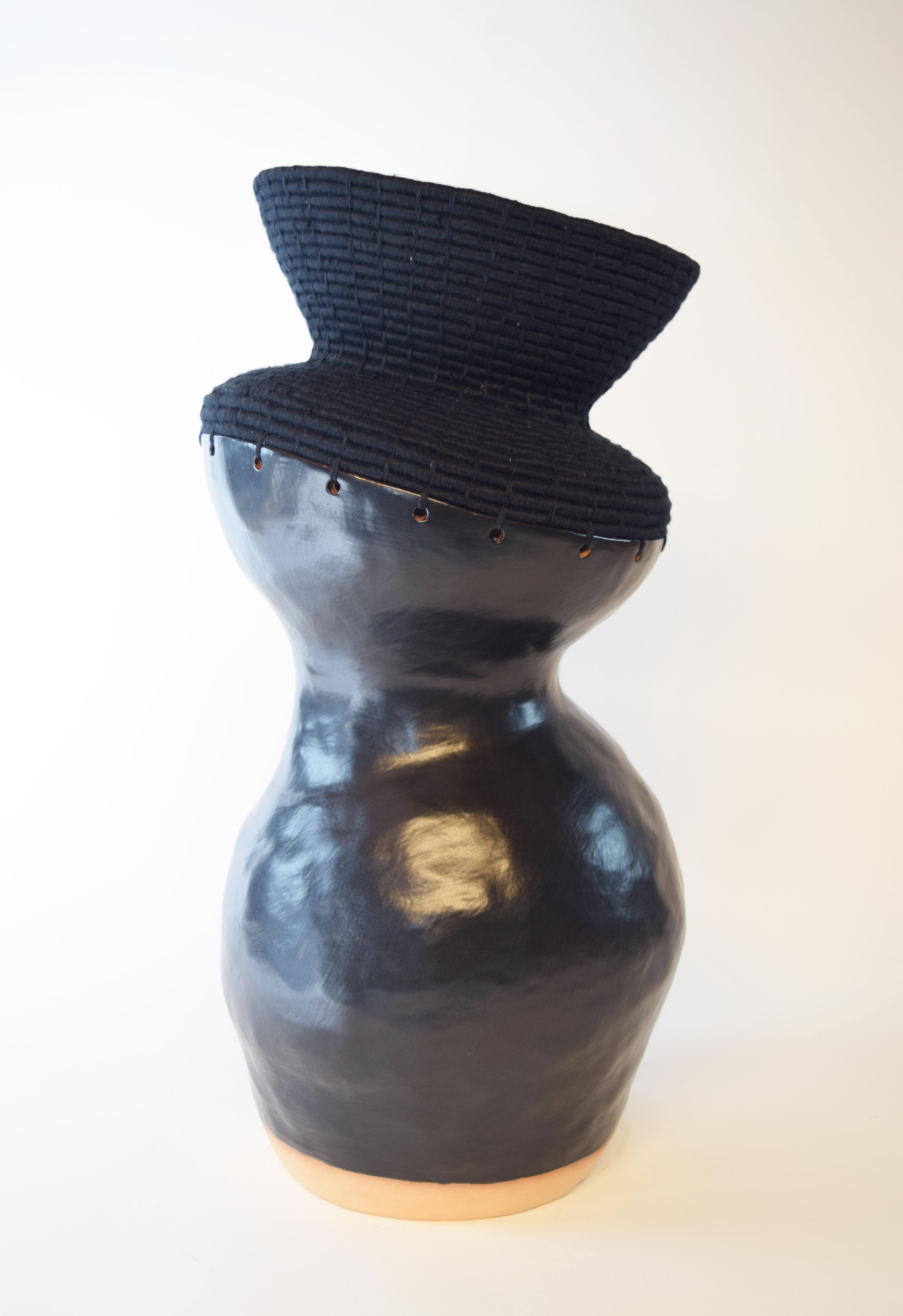 761 Black vessel by Karen Gayle Tinney
Dimensions: D 20.5 x W 20.5 x H 46.5 cm 
Material: Stoneware with cream, shino glaze, Black cotton.

Karen Gayle Tinney is an artist and designer whose work consists of pieces that combine ceramic and