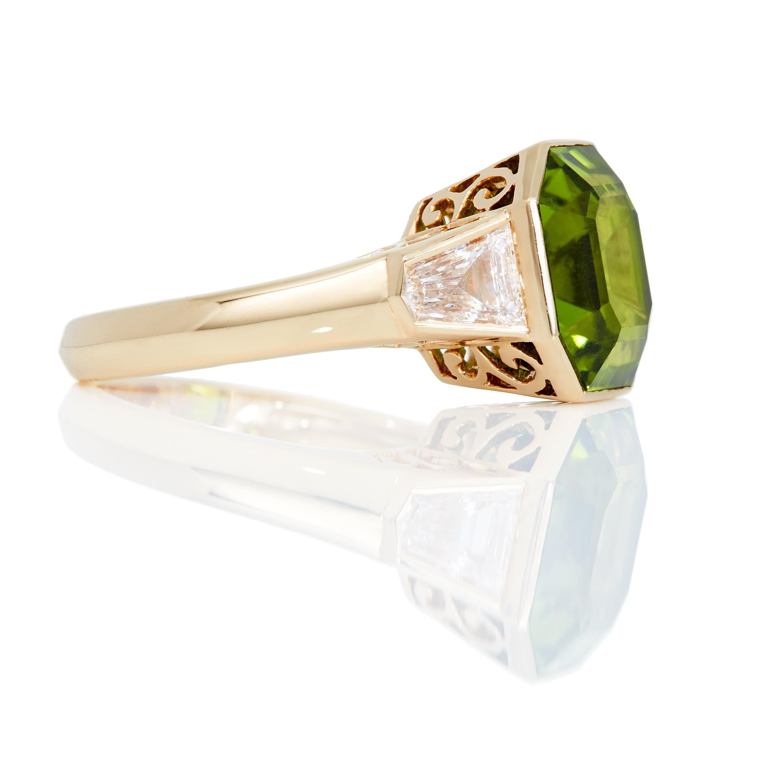Rare to see such a beautifully cut Peridot as this one.  This ring features a stunning 7.0 Carat Asscher cut bezel set Peridot with 0.65 Carats of Bullet-shaped Diamonds on the side.  The filagree design in the profile ensures beauty from every