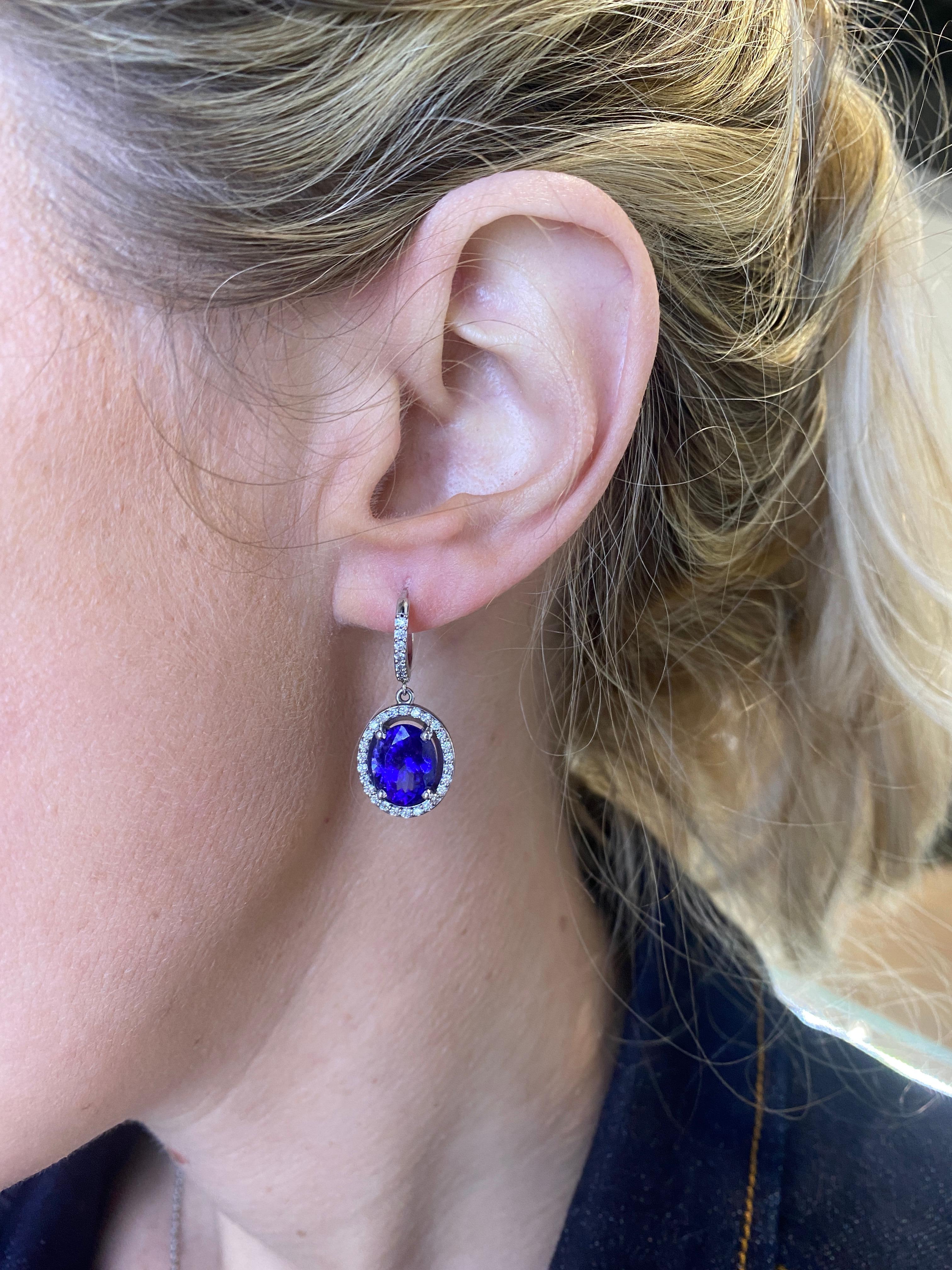 These drop earrings feature 7.68 carat total weight in oval Tanzanites accented by a halo of 0.43 carat total weight in round diamonds set in 14 karat white gold.
Measurements: Approximately 30mm in length.