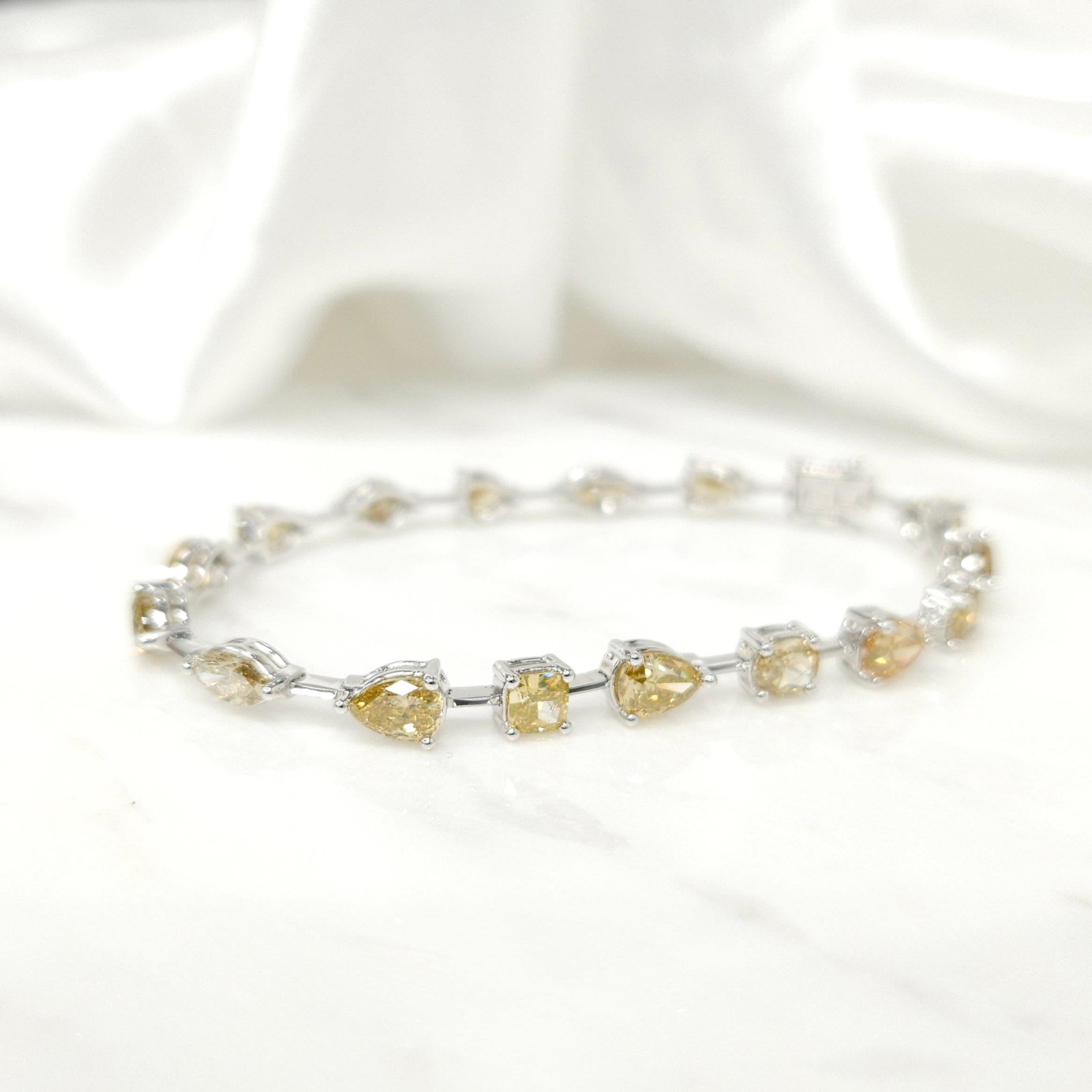 Introducing our exquisite 18K white gold tennis bracelet, a true embodiment of luxury and sophistication. This stunning piece of jewelry is meticulously crafted to showcase the mesmerizing allure of multi-shaped natural diamonds, all in a