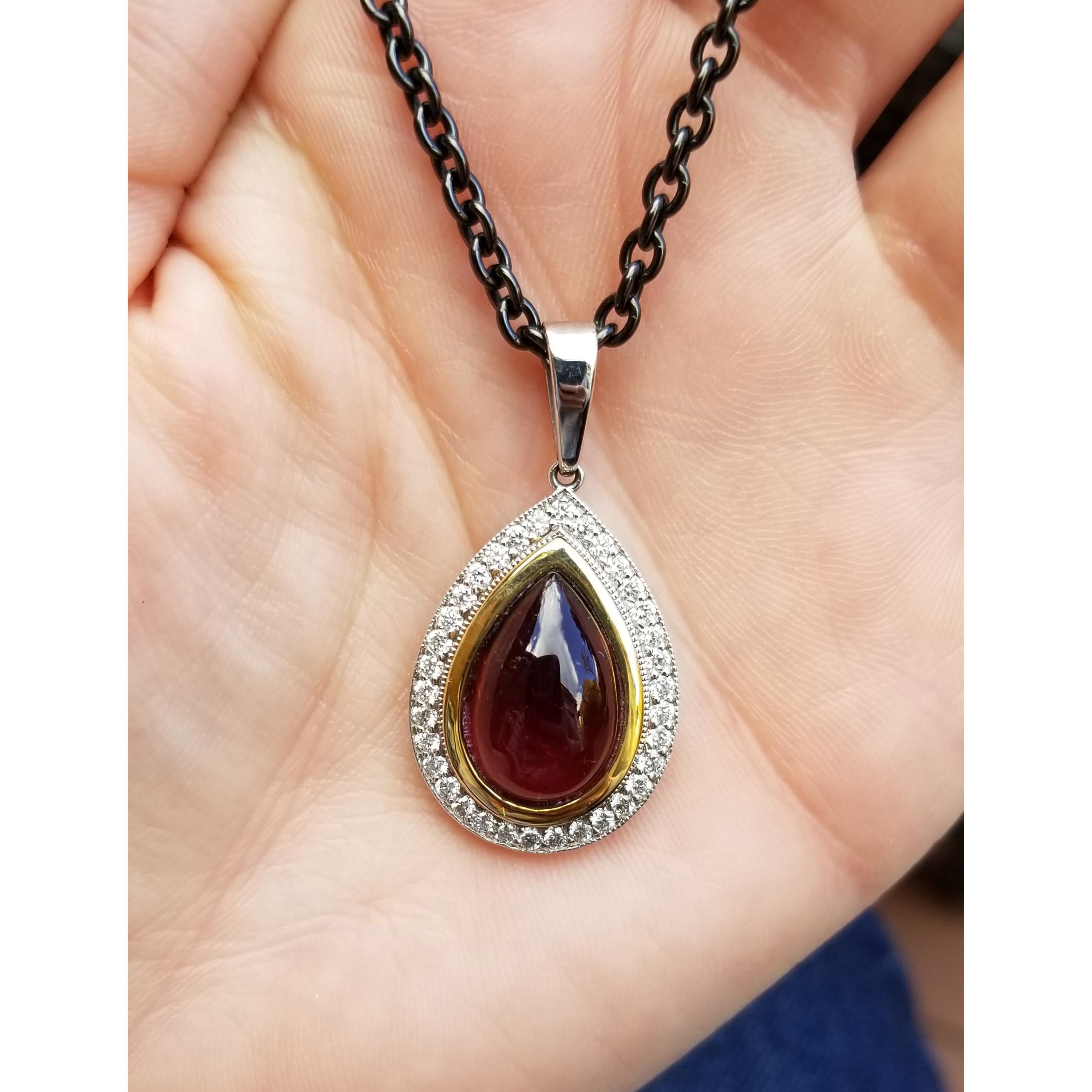 Richly saturated pinkish red tourmaline in pear-shaped cabochon is the statement making centerpiece of this candy-hued pendant necklace.

This elegantly pared-down pendant was designed to perfectly frame the center tourmaline. The clean and sharp