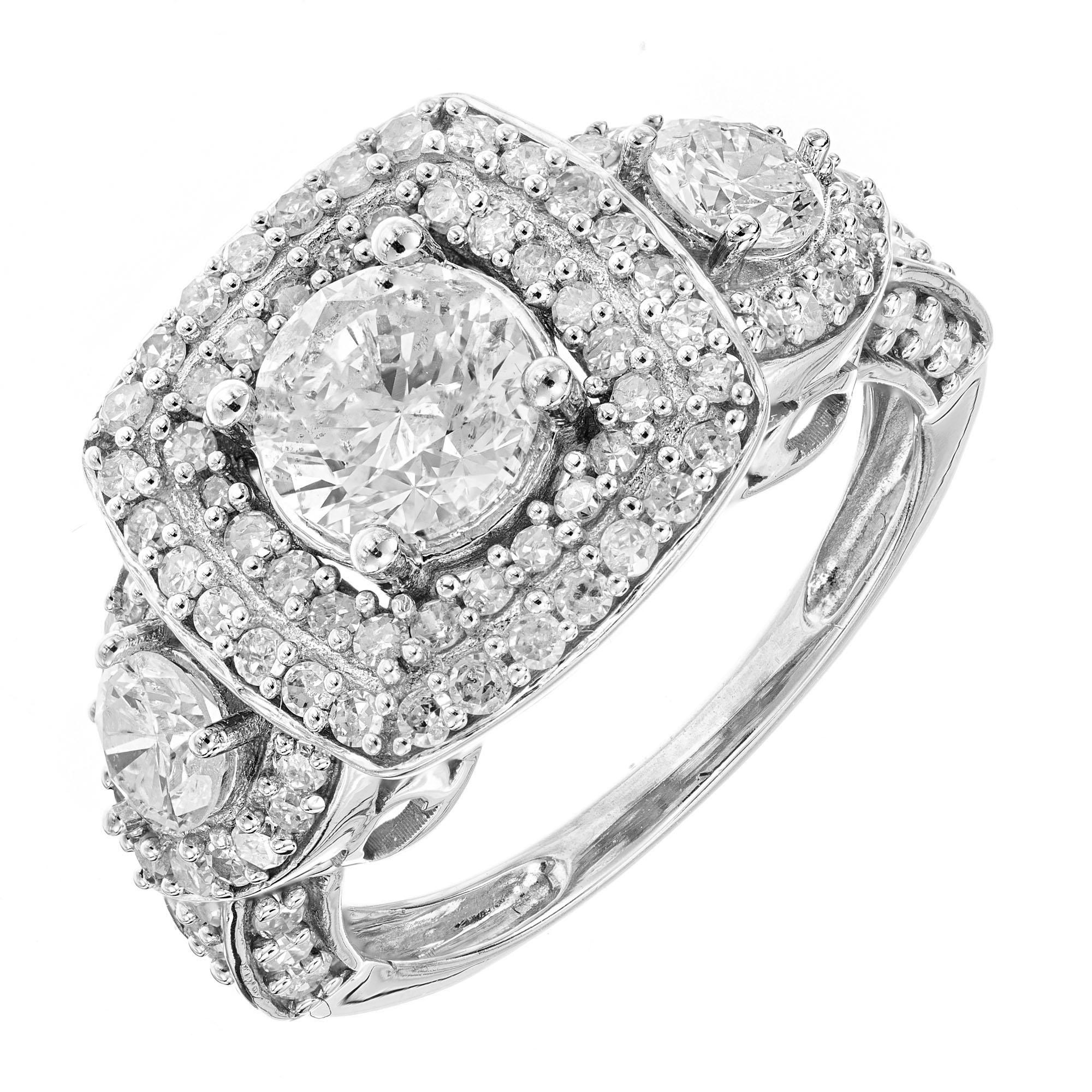 Three-stone diamond engagement ring. .77ct center brilliant cut diamond with a double halo of diamonds accented by 2 brilliant cut side diamonds with halos of round cut diamonds, in a platinum setting. 

90 round diamonds approx. total weight