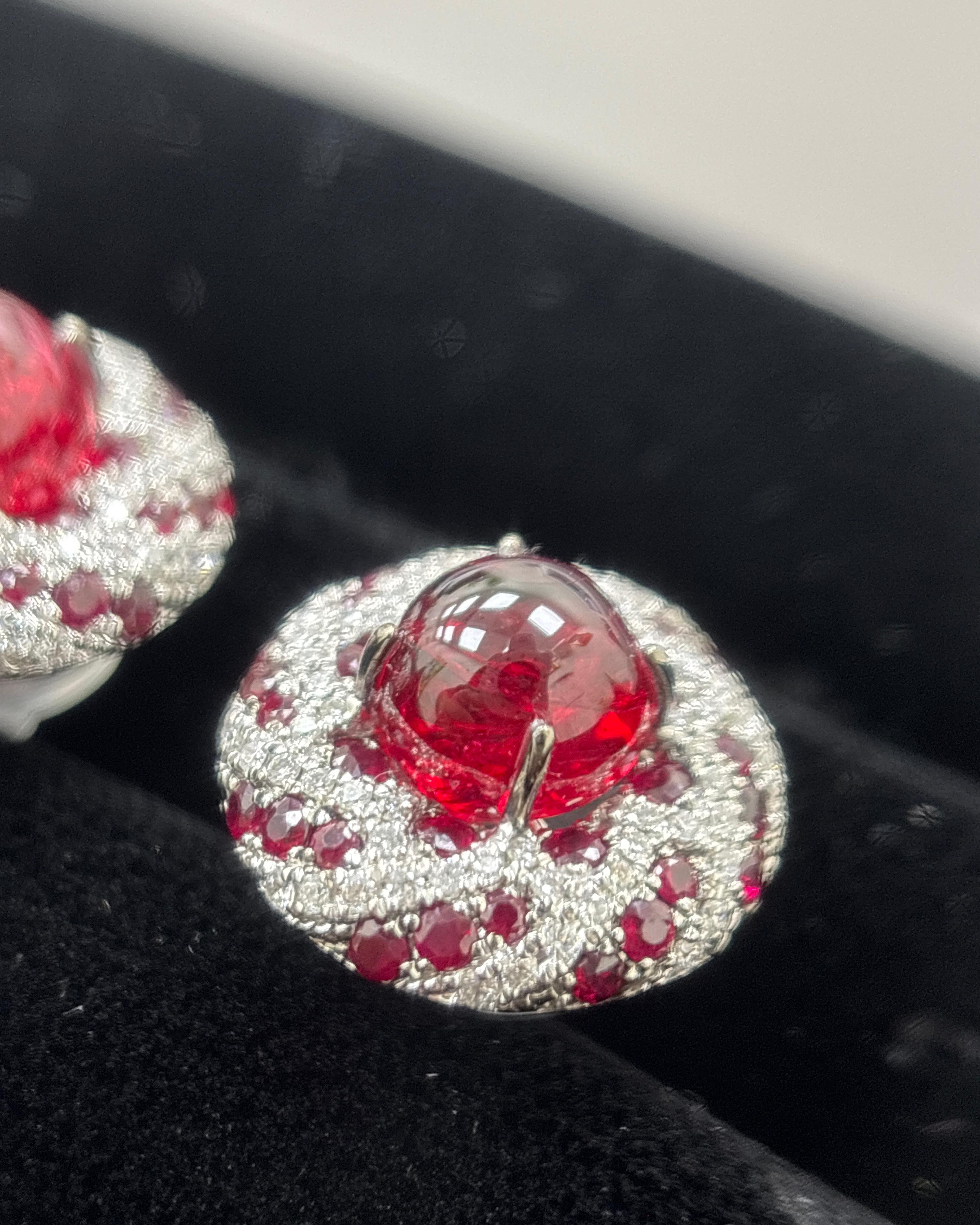 Ti presentiamo un paio di eccezionali orecchini con spinello cabochon Burma no heat da 7,7 carati, rubino e diamante, realizzati magistralmente in oro bianco 18 carati. Questi straordinari orecchini presentano un paio di cabochon di spinello rosso