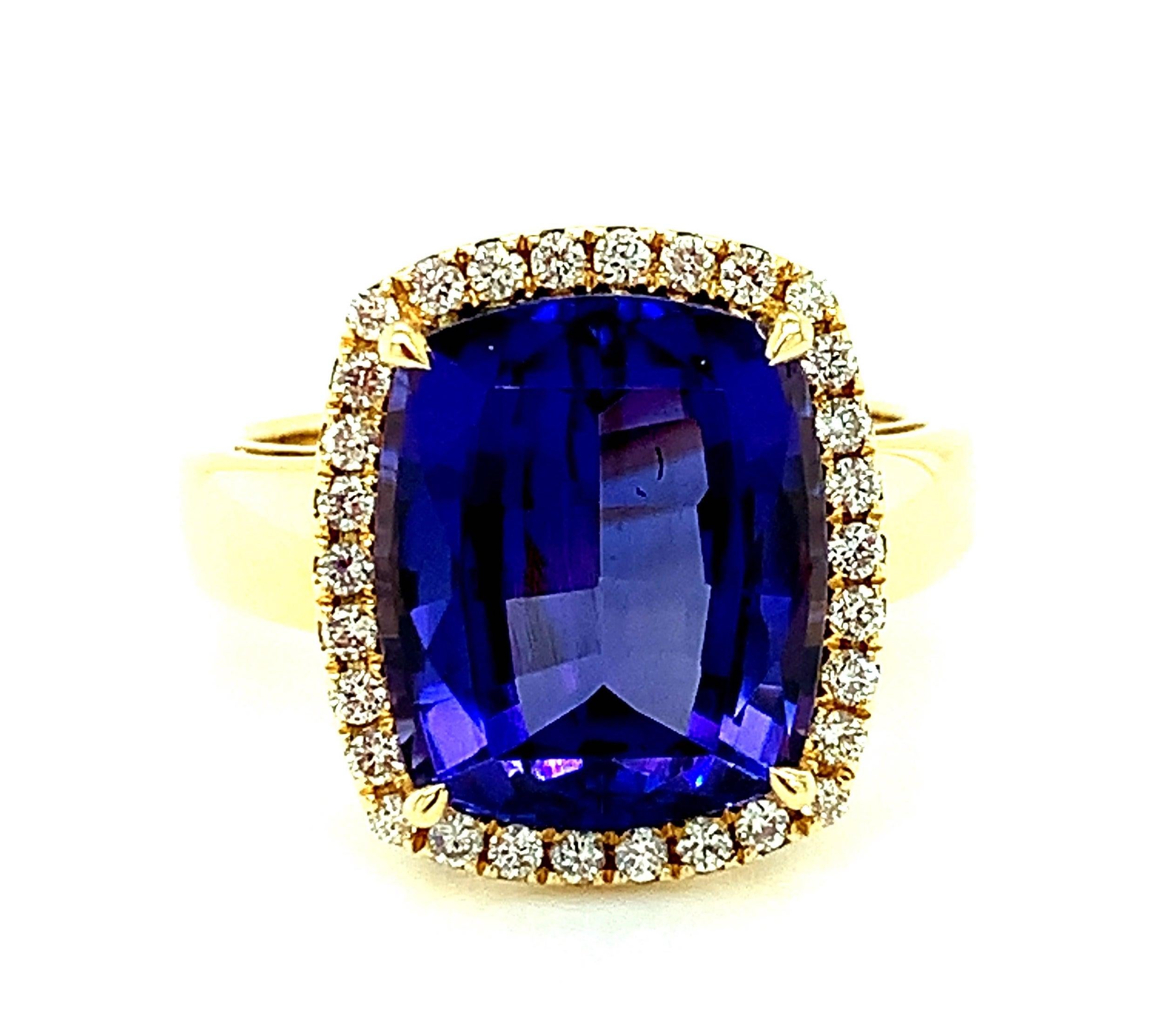 This stunning, quintessential cocktail ring features a spectacular gem-quality tanzanite with intense, violet blue color. The tanzanite is cushion shaped and weighs an impressive 7.70 carats! It is surrounded by a halo of sparkling, brilliant cut
