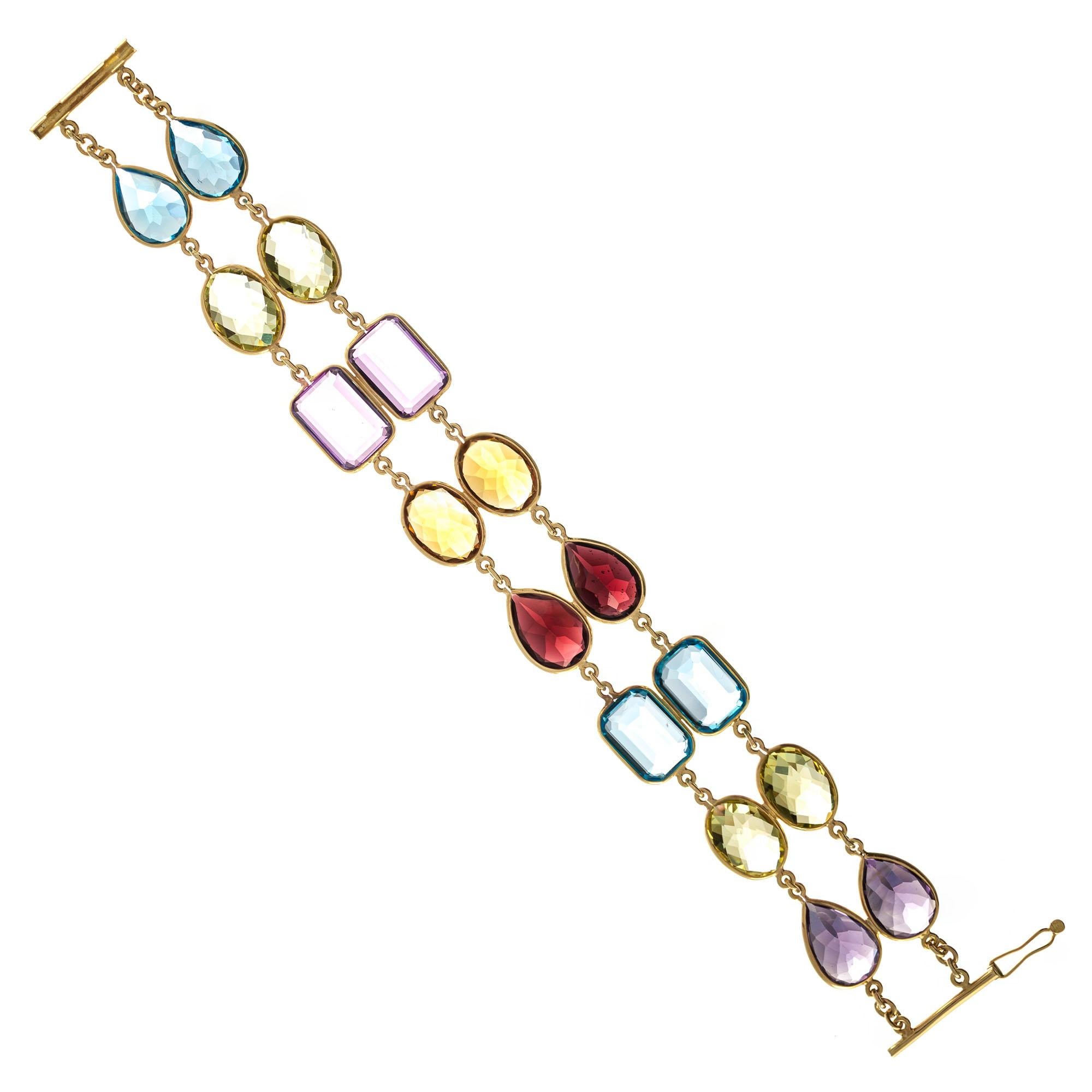 Bright multi-color two row gemstone bracelet in 14k yellow gold 

2 pear shape purple amethyst, approx. 9.00cts 
2 rectangular purple amethyst, approx. 12.00cts
2 pear shape blue topaz, approx. 11.00cts
2 rectangular blue topaz, approx. 14.00cts
2