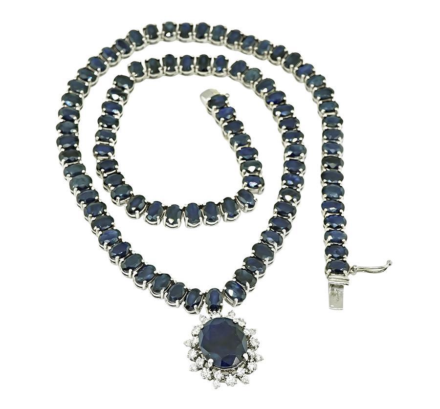 This is a magnificent 14k white gold pendant necklace. The necklace is set with lovely oval cut sapphires that weigh approximately 77.00ct. The sapphires are accentuated by sparkling round cut diamonds that weigh approximately 0.65ct. The color of