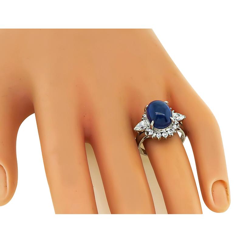 This is an amazing platinum ring. The ring is centered with a lovely cabochon Ceylon sapphire that weighs approximately 7.72ct. The center stone is accentuated by sparkling pear and round cut diamonds that weigh approximately 1.38ct. The color of