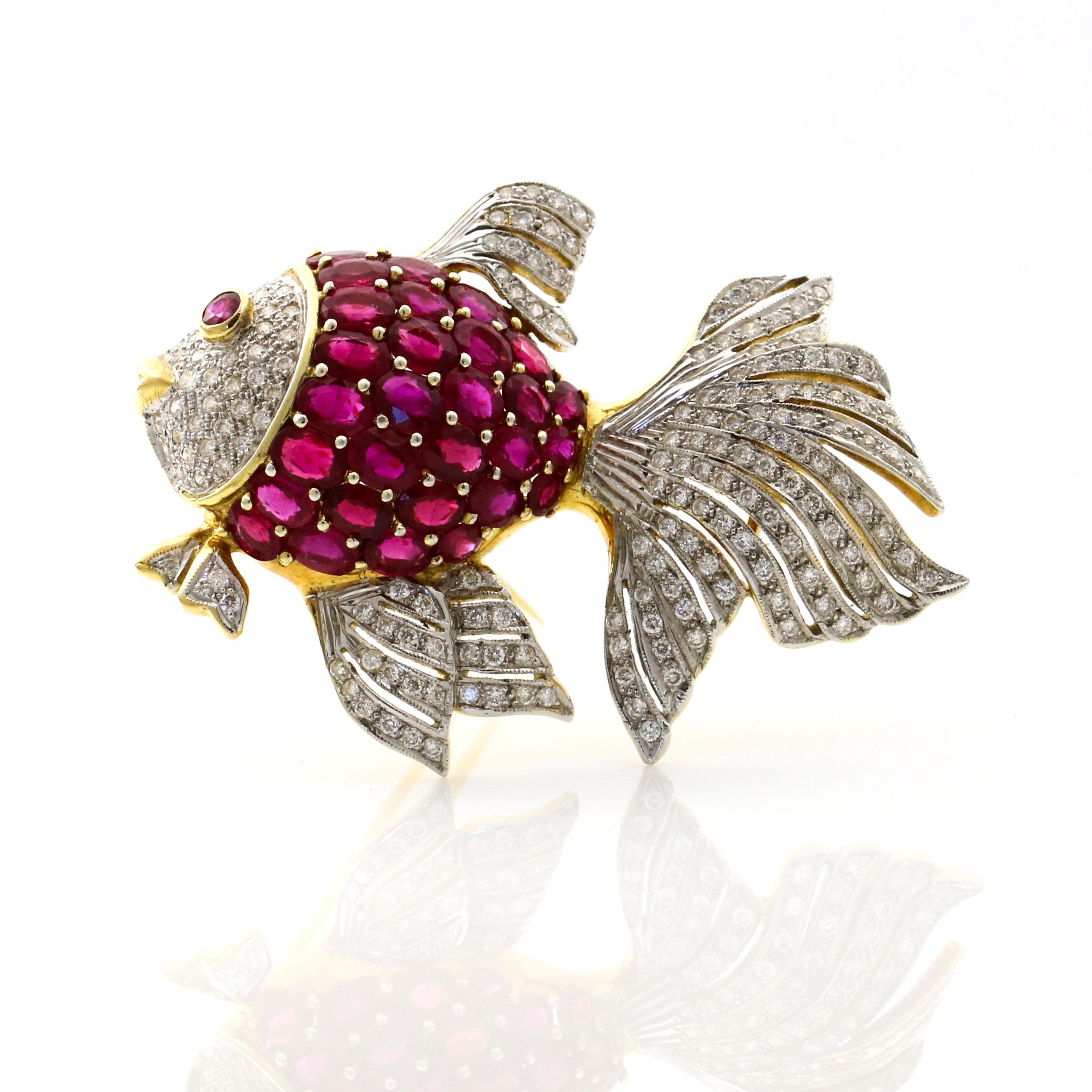 Fish brooch in 18-karat yellow and white gold with rubies and diamonds. The fish body is prong set with 29 oval cut natural rubies, and 1 bezel set cabochon ruby on eye. The fish face and fins are encrusted with numerous near colorless round