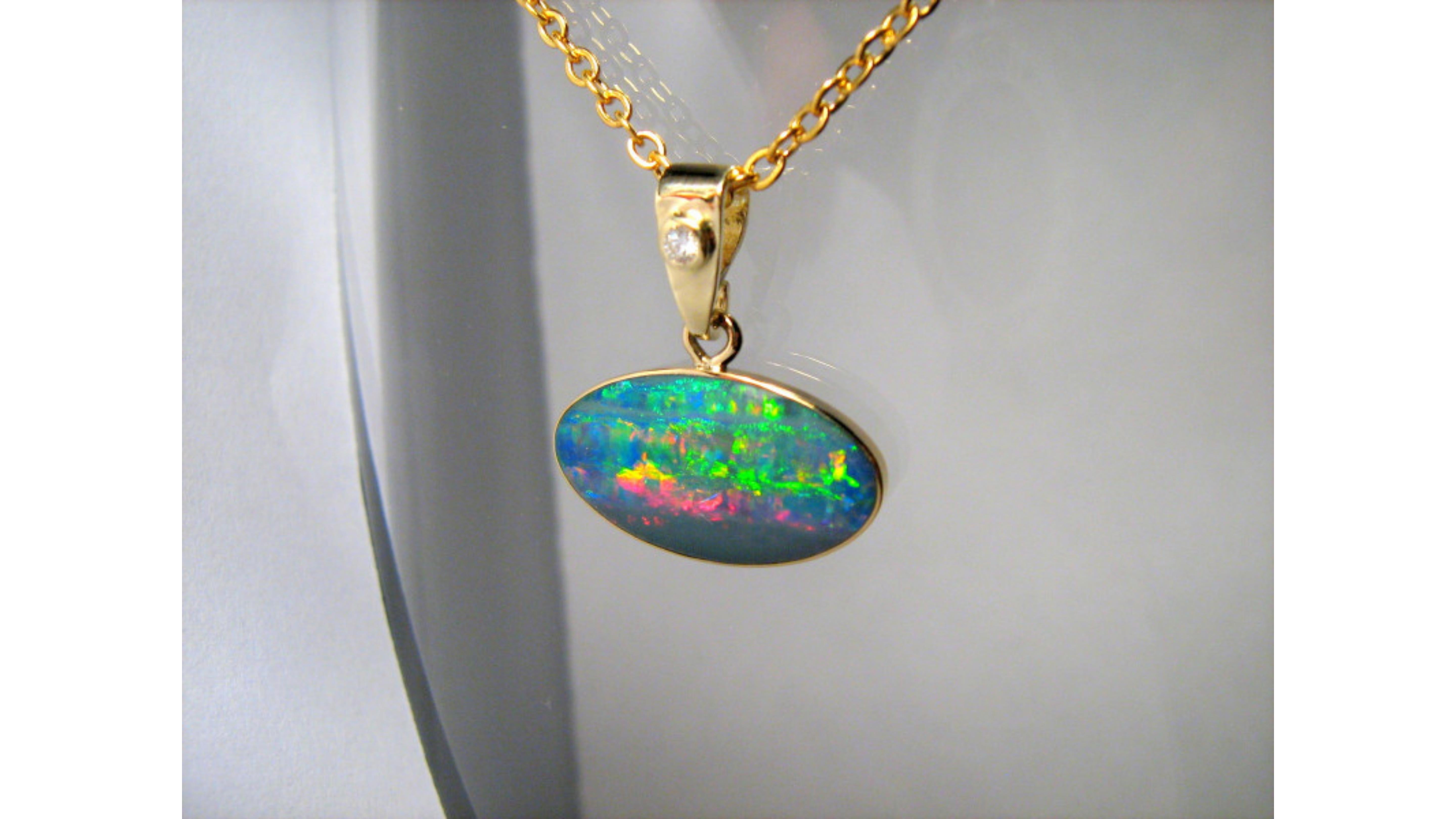 Australian Opal Necklace Sterling Silver . This shows off very bright colors Green Yellow Blue Pink Red and stands out with the Diamond too and set in 14 Karat Yellow Gold. This is from Coober Pedy South Australia 

WEIGHT: 4.8 carats (whole