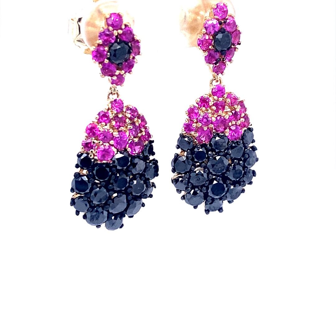 Beautiful 7.75 Carat Black Diamond and Pink Sapphire Drop Earrings in 14K Yellow Gold.  This intricate design has 35 Round Cut Diamonds that weigh 5.14 carats.  The Black Diamond is a natural diamond that has been color-treated to enhance the black