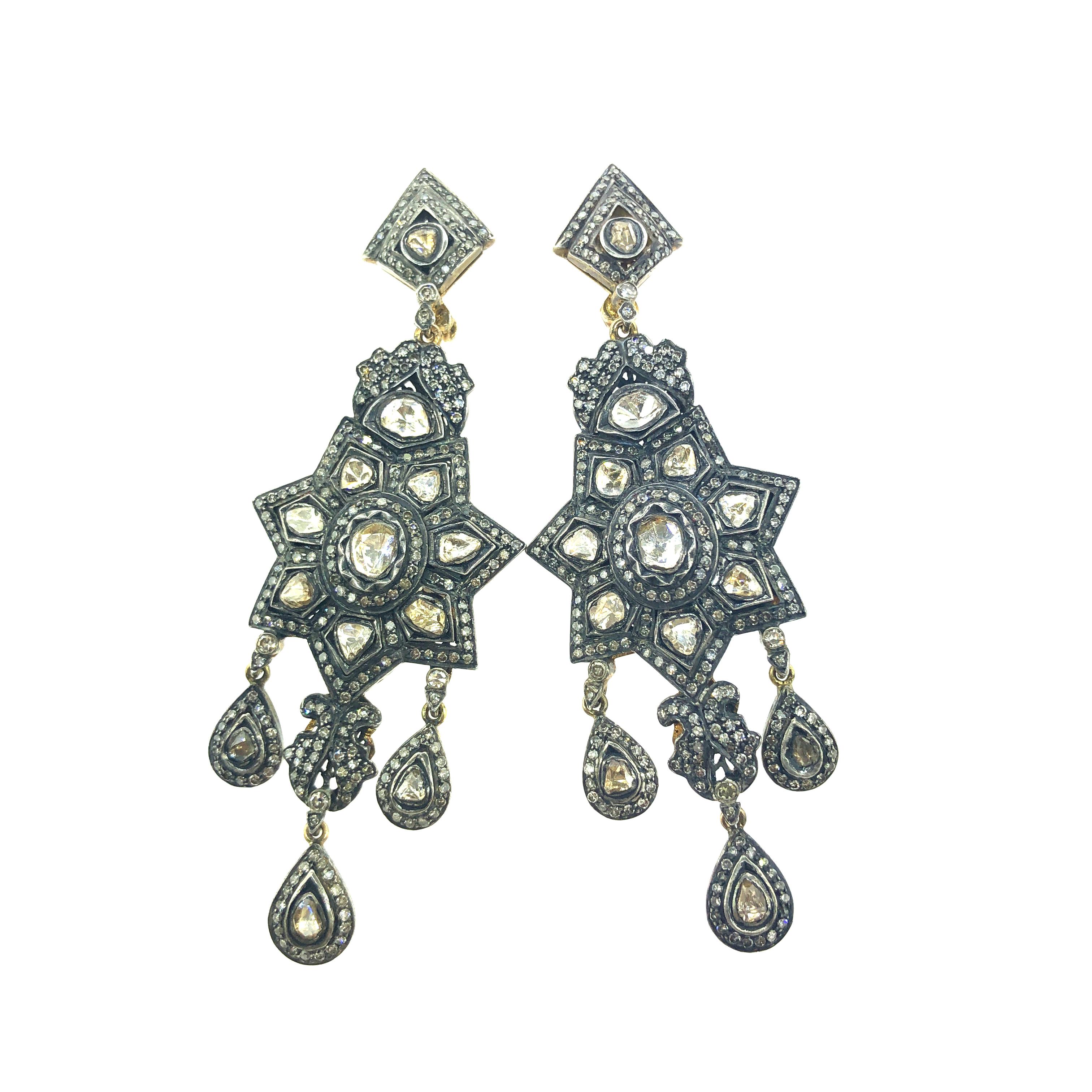 These rose cut diamond long, chandelier earrings feature larger, asymmetrical Polki diamonds encircled by diamonds pave set in oxidized sterling silver and joined by smaller diamonds. Set in this traditional Indian (Mughal) style, the earrings are